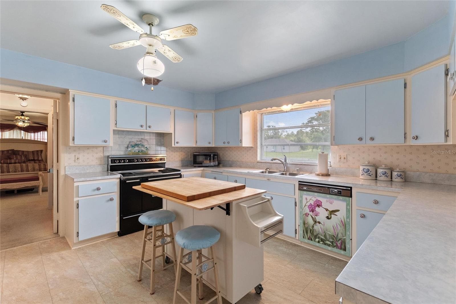 The kitchen is located right off of the formal dining room and has an entry into the informal areas. The doorway in the rear of the picture leads into the private suite. - 6197 AMARYLLIS DR, INDIAN LAKE ESTATES
