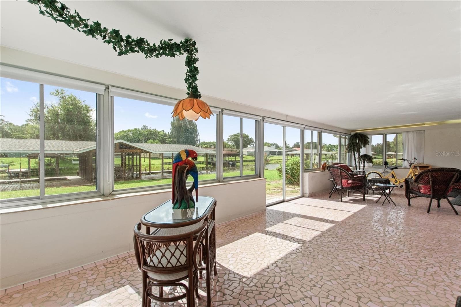 Sun room with view of boat house. - 6197 AMARYLLIS DR, INDIAN LAKE ESTATES