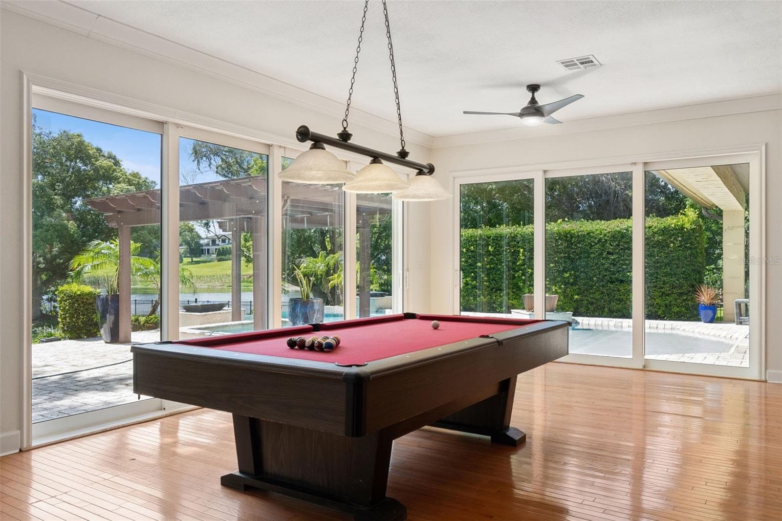 Game Room with view of the Pool and Lake. Beautiful natural wood floor. Sliding Energy effcient doors for the open air experience - 1629 HEMPEL AVE, WINDERMERE