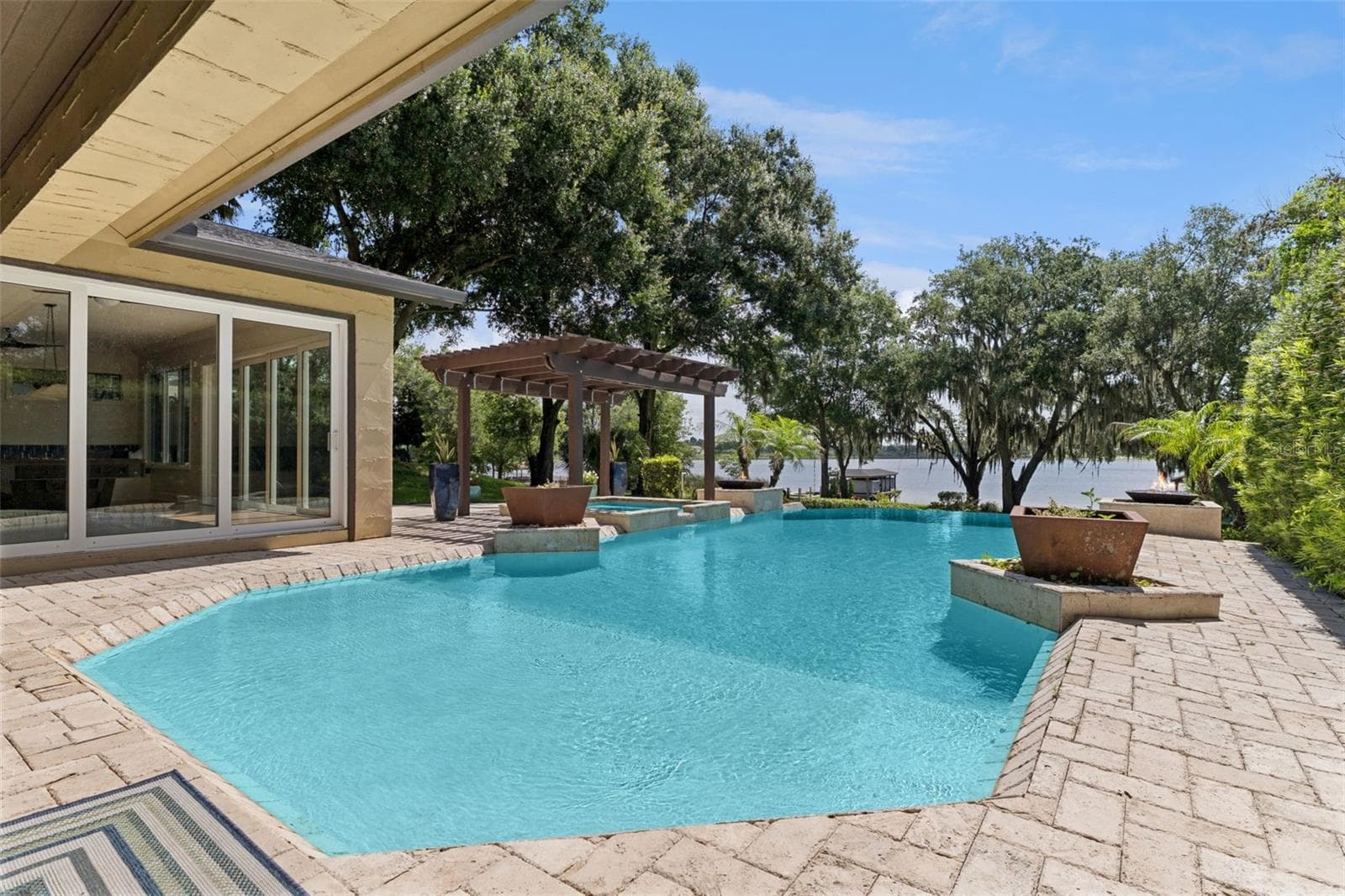 Infinity Pool and Spa. Decorative planters and two natural gas fed fire pit features complete the luxury pool experience - 1629 HEMPEL AVE, WINDERMERE