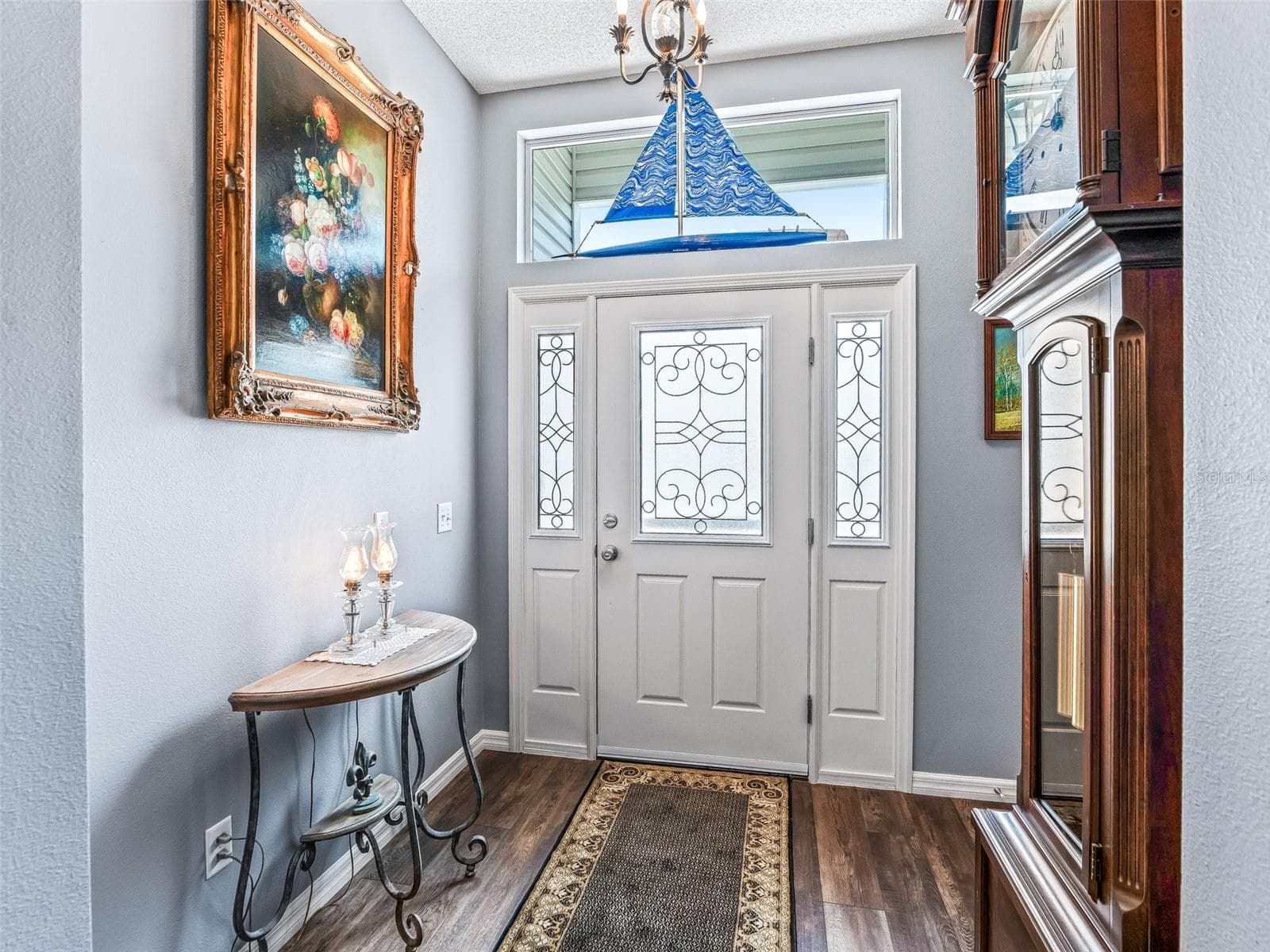 Decorative glass front door with matching sidelights and transom window fills the entry with natural light and creates a polished first impression. - 17946 SE 87TH MELROSE CT, THE VILLAGES