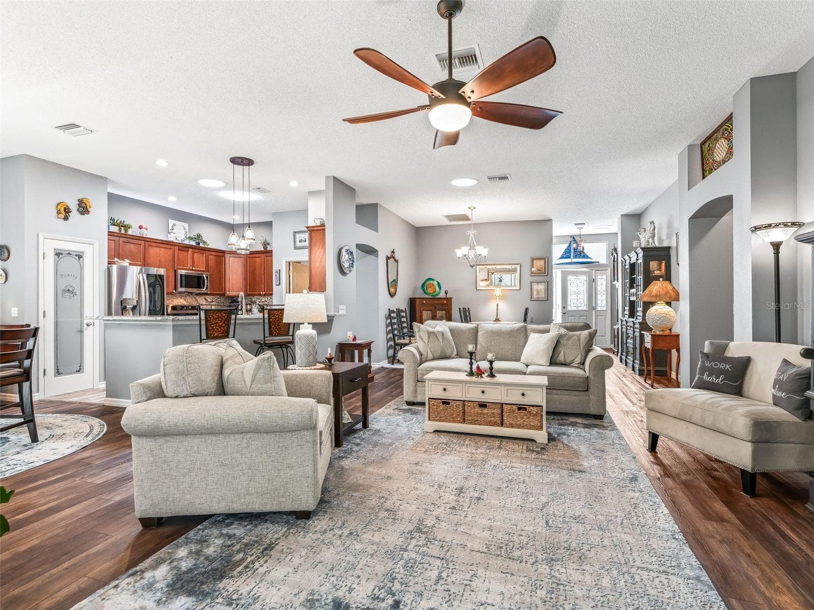 View from the living room showcases the home’s flowing layout, connecting the kitchen, dining area, and main gathering space for effortless entertaining. - 17946 SE 87TH MELROSE CT, THE VILLAGES