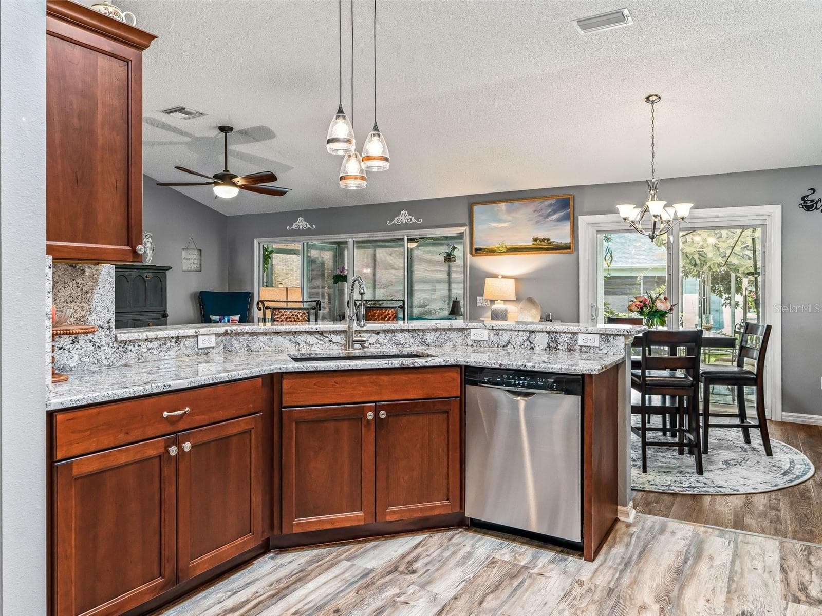 A wide granite breakfast bar with pendant lighting provides additional prep space and casual seating while maintaining an open connection to the dining and living areas. - 17946 SE 87TH MELROSE CT, THE VILLAGES