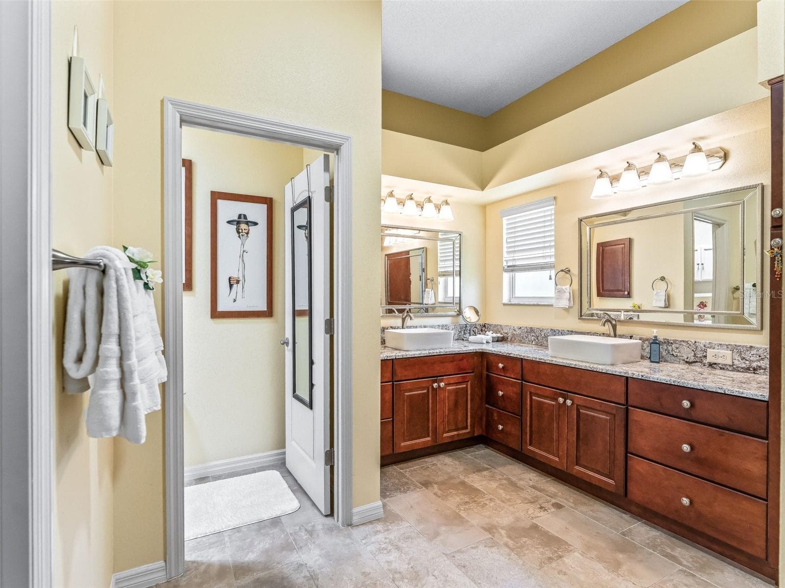 Large primary bath features an extended vanity with abundant cabinetry, generous counter space, dual mirrors, and bright overhead lighting. - 17946 SE 87TH MELROSE CT, THE VILLAGES