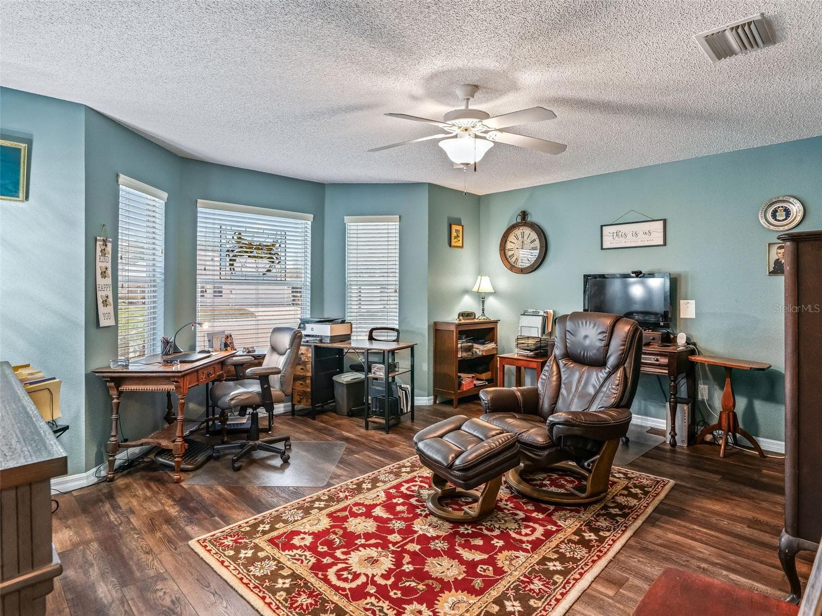 Spacious bonus room offers abundant natural light, wood-look flooring, a ceiling fan, and plenty of space for a home office, hobby room, 2nd Guest Bedroom, or additional sitting area. - 17946 SE 87TH MELROSE CT, THE VILLAGES