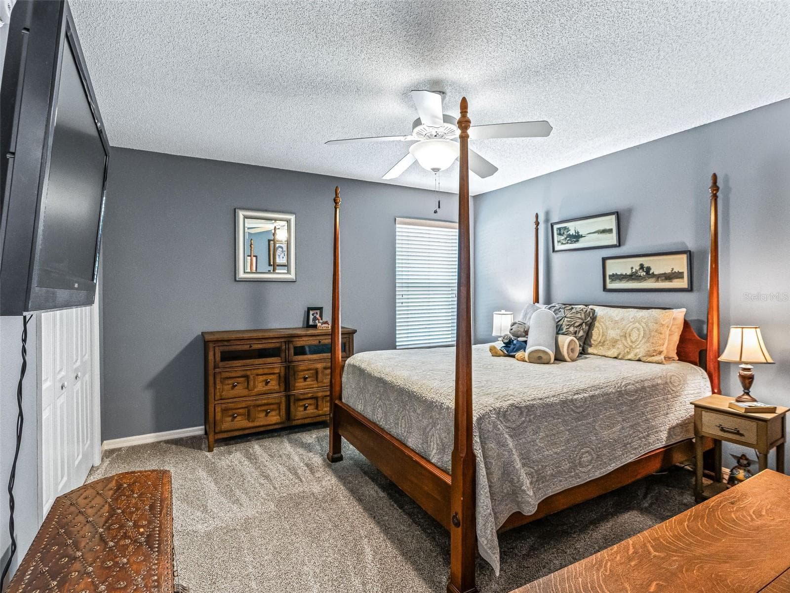 Comfortable guest bedroom features soft carpeting, a ceiling fan, neutral décor, and multiple windows that bring in natural light. - 17946 SE 87TH MELROSE CT, THE VILLAGES