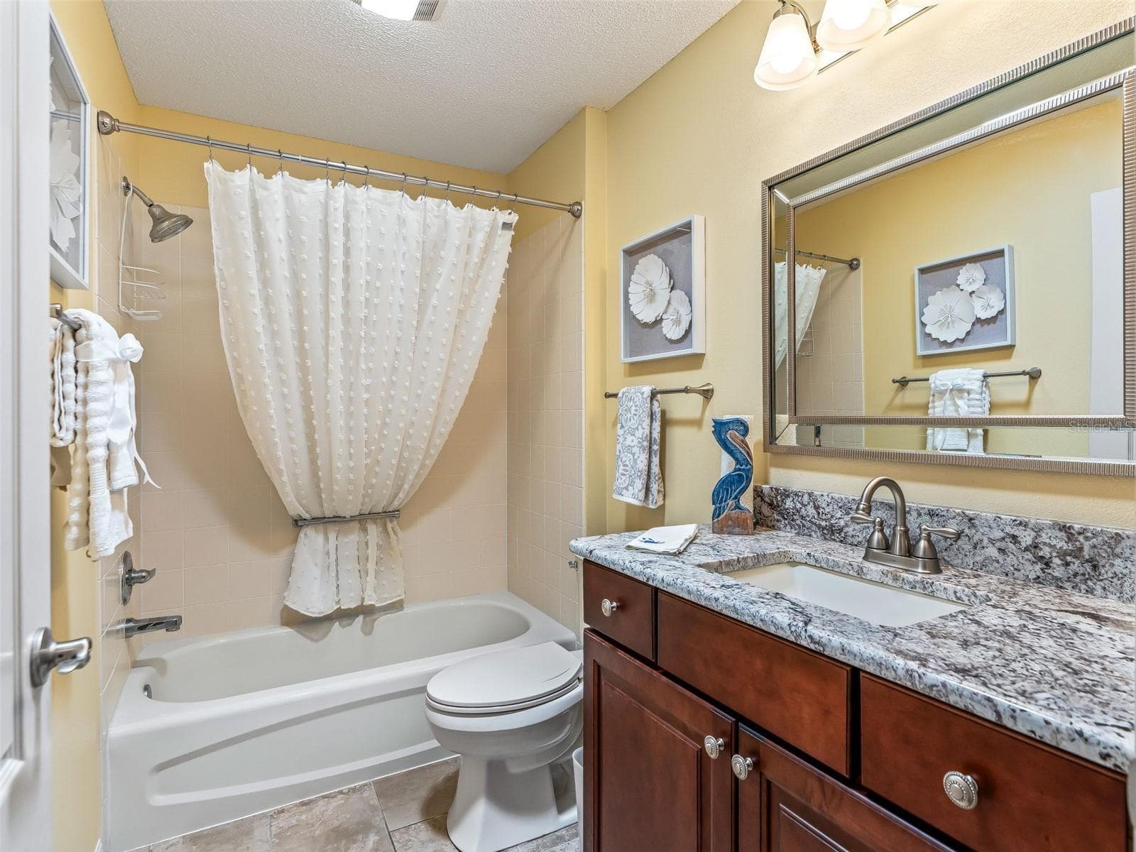 Upgraded Guest Bathroom with plenty of counterspace on the granite rich toned vanity with a tub and shower unit. - 17946 SE 87TH MELROSE CT, THE VILLAGES