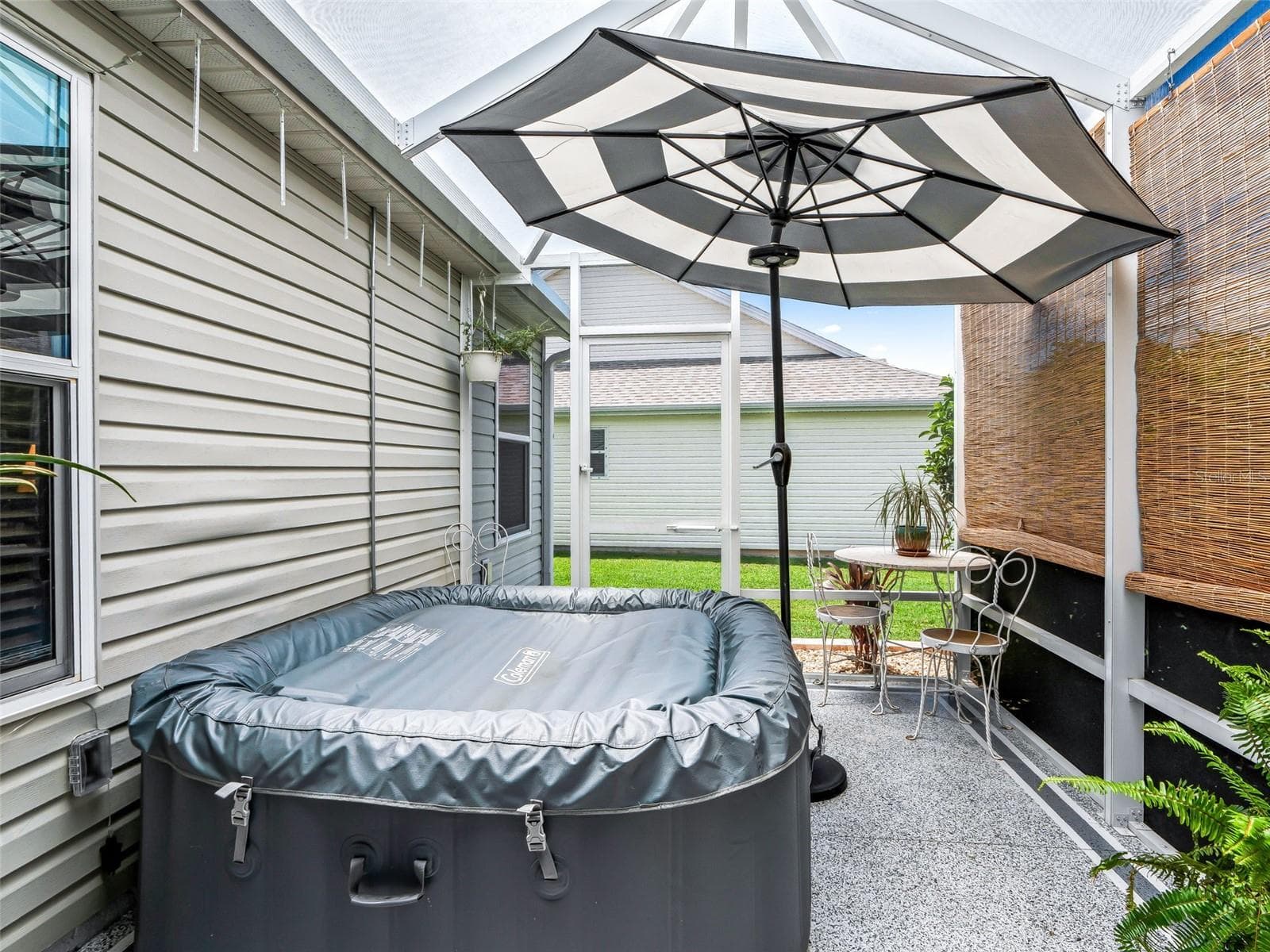 Screen-enclosed patio creates a private setting for the hot tub, with room for additional seating and easy access from the adjoining lanai. - 17946 SE 87TH MELROSE CT, THE VILLAGES