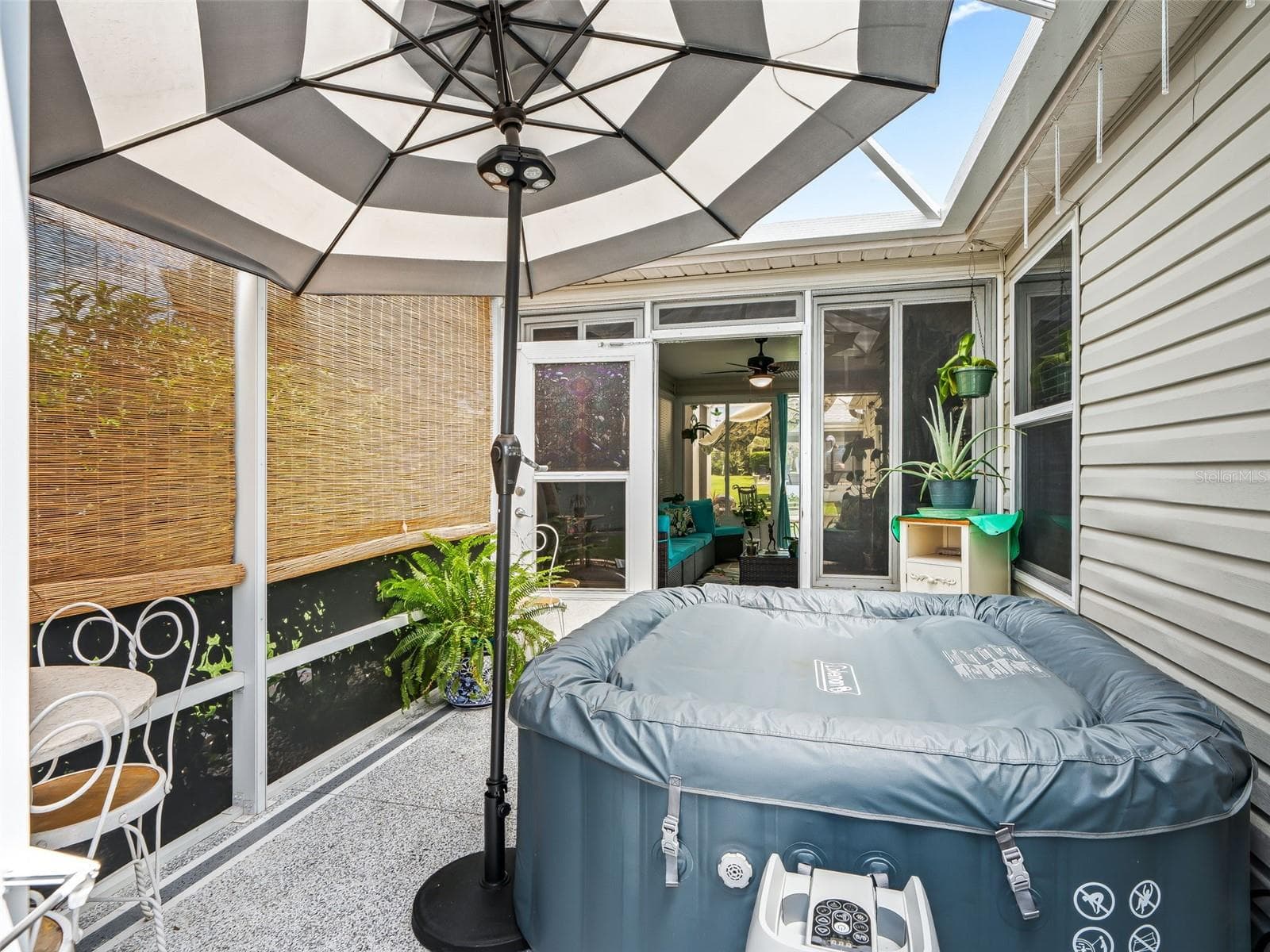 A freestanding canopy and screened enclosure provide shade and privacy, creating a relaxing outdoor space to enjoy the spa throughout the year. - 17946 SE 87TH MELROSE CT, THE VILLAGES
