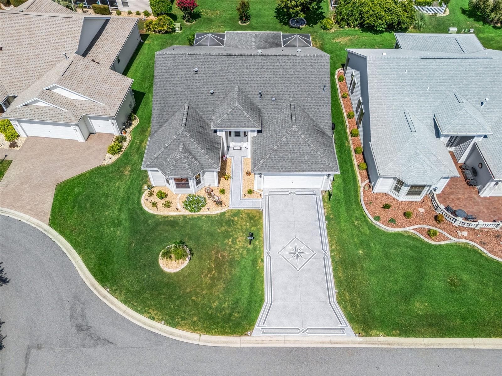 Elevated perspective highlights the home’s attractive curb appeal, spacious driveway, landscaped lot, and quiet residential setting. - 17946 SE 87TH MELROSE CT, THE VILLAGES