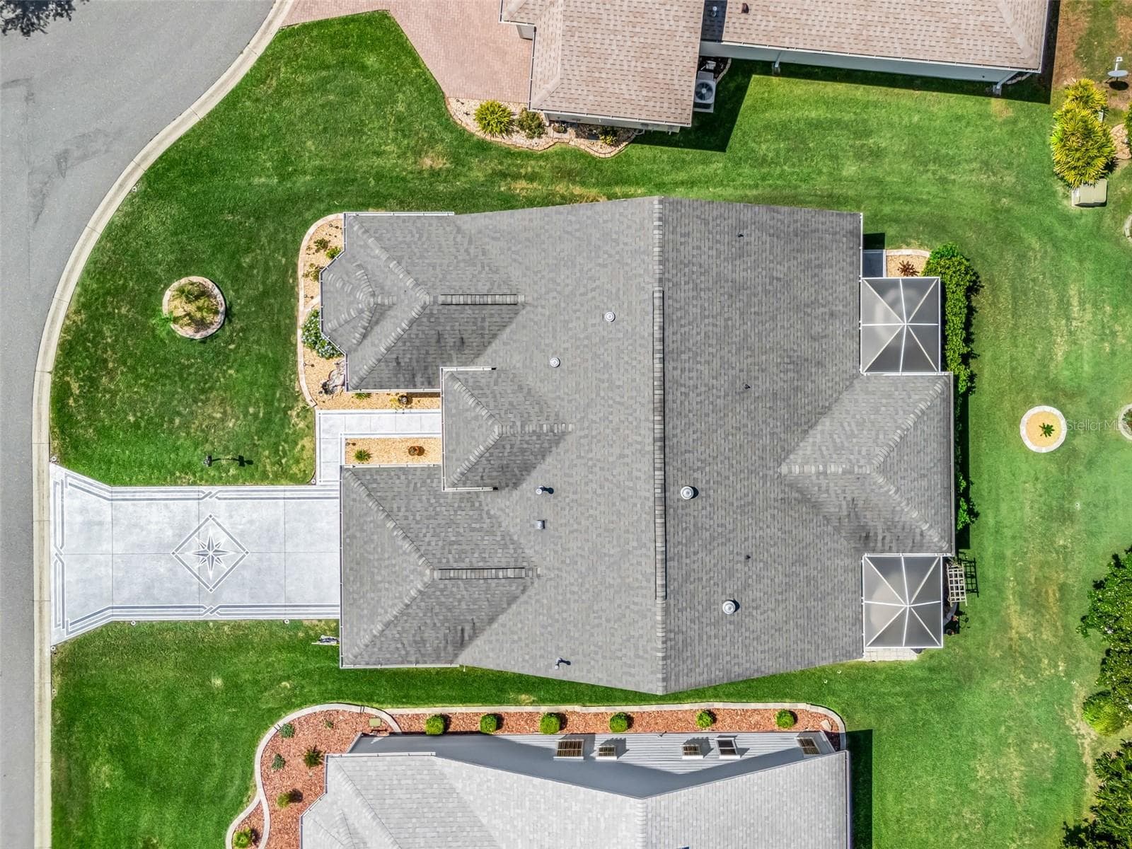 Top-down aerial view showcases the home’s roofline, screened rear living area, landscaping, and well-defined homesite. - 17946 SE 87TH MELROSE CT, THE VILLAGES