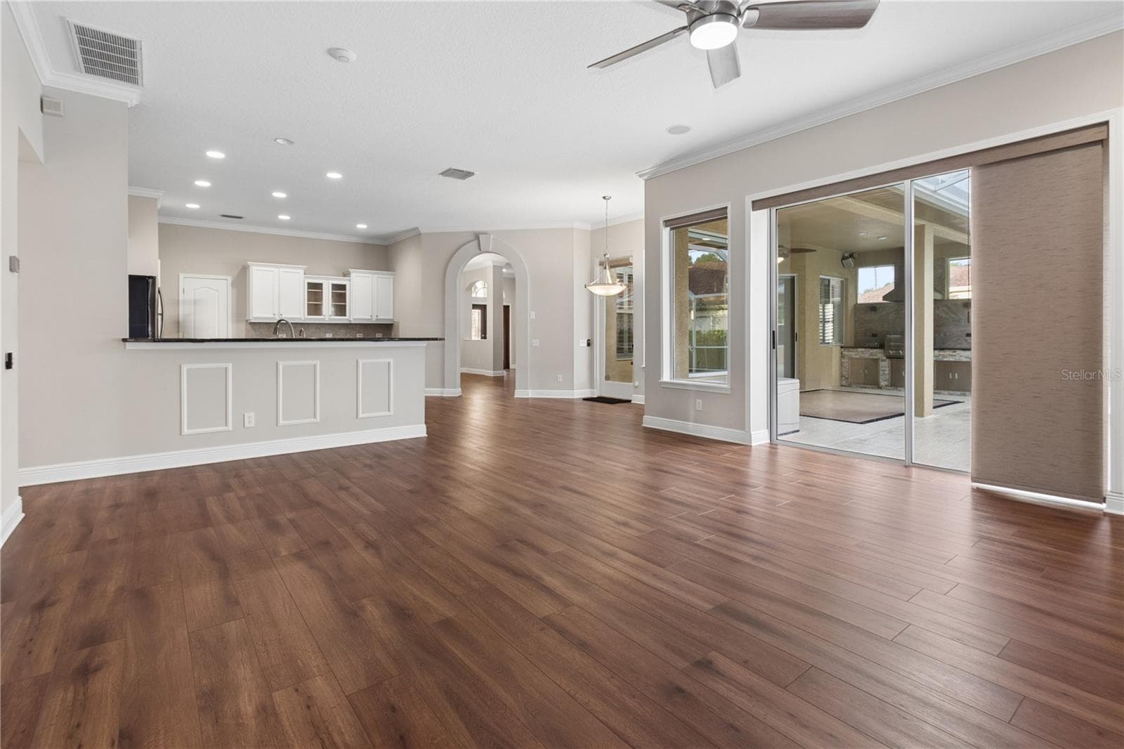 The inviting main living room features sliding glass doors that open to the screened lanai and pool, while elegant French doors lead to a versatile flex room perfect for a home office, gym, or playroom. - 26920 WINGED ELM DR, WESLEY CHAPEL