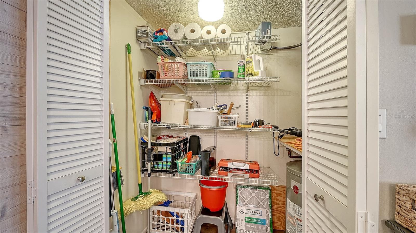 Storage/Mechanical Closet in Living Room with HVAC system and hot water heater. - 1646 STICKNEY POINT RD #101, SARASOTA