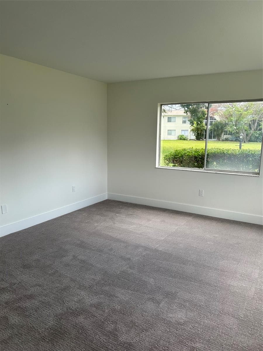 Primary bedroom with view of the grounds in rear of the building. - 4520 OVERLOOK DR NE #132, ST PETERSBURG