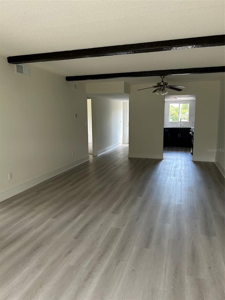 Living room area and dining area and kitchen beyond, viewed from the Florida room. Short hallway seen on the left leads to the front door. - 4520 OVERLOOK DR NE #132, ST PETERSBURG