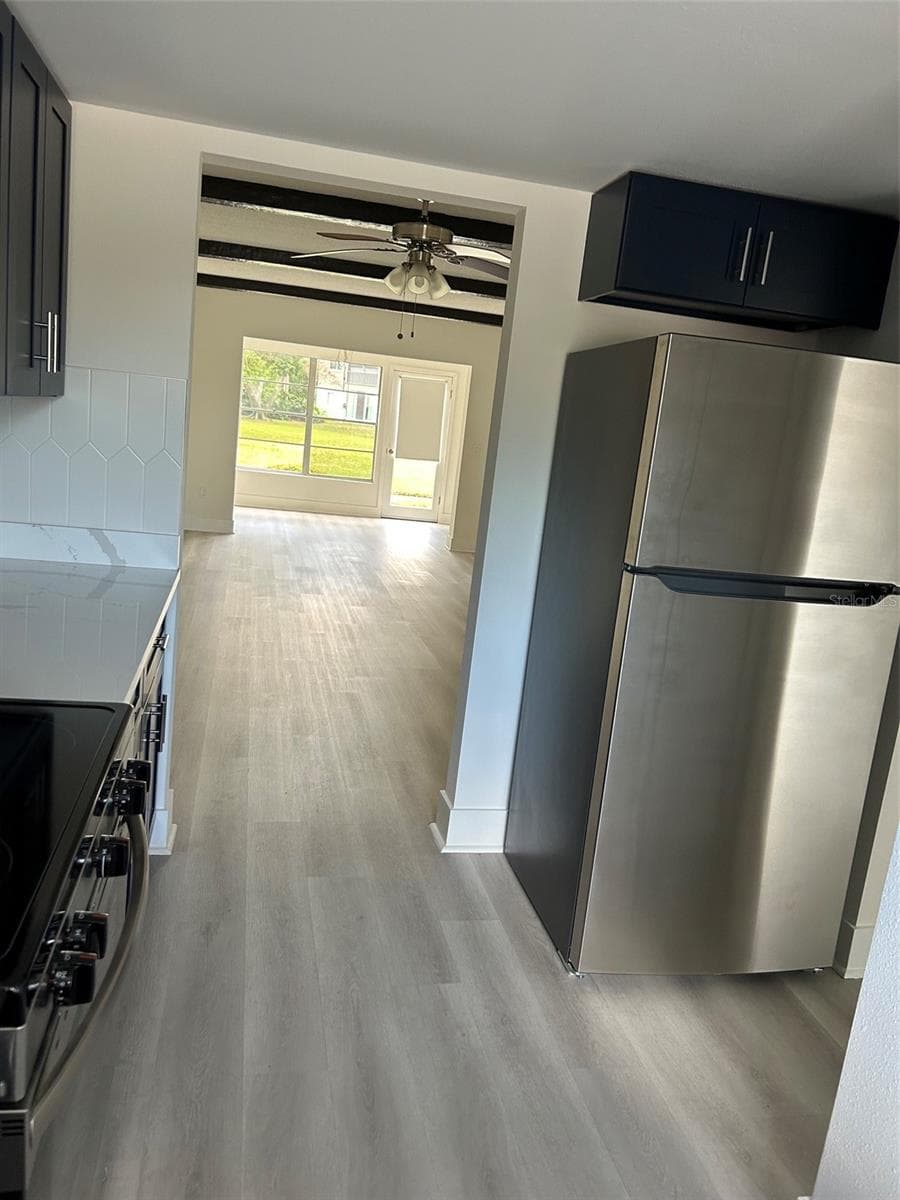 Looking from kitchen through dining and living areas to the Florida room and back door beyond. - 4520 OVERLOOK DR NE #132, ST PETERSBURG