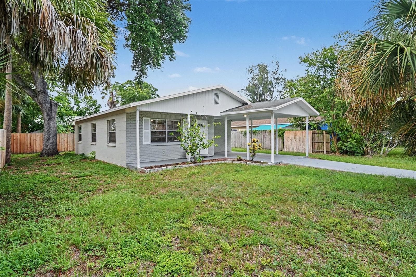 Fresh curb appeal with concrete block construction and a covered carport. - 5733 66TH LN N, ST PETERSBURG