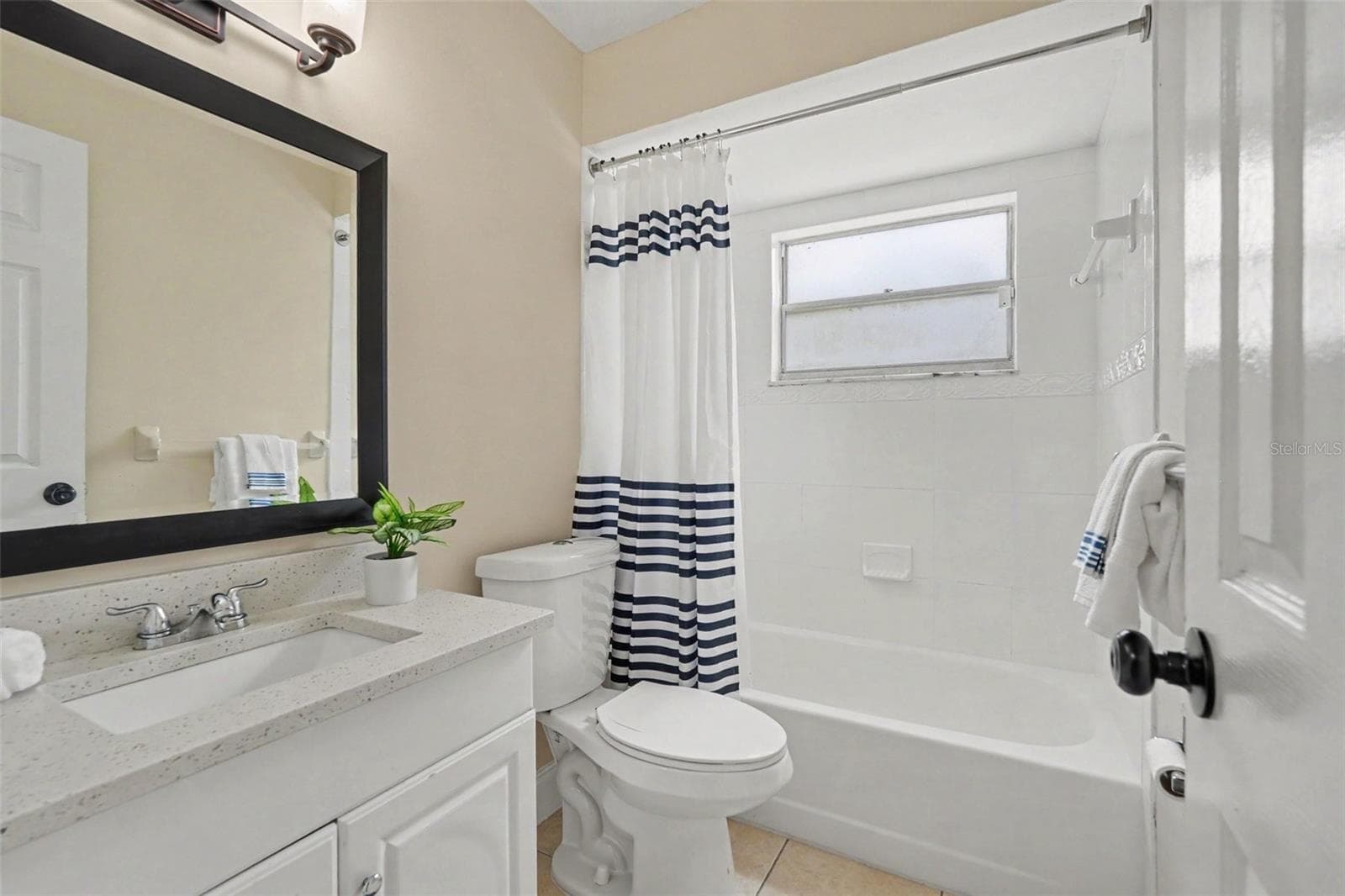 An updated bathroom with a fresh, neutral design. - 5733 66TH LN N, ST PETERSBURG
