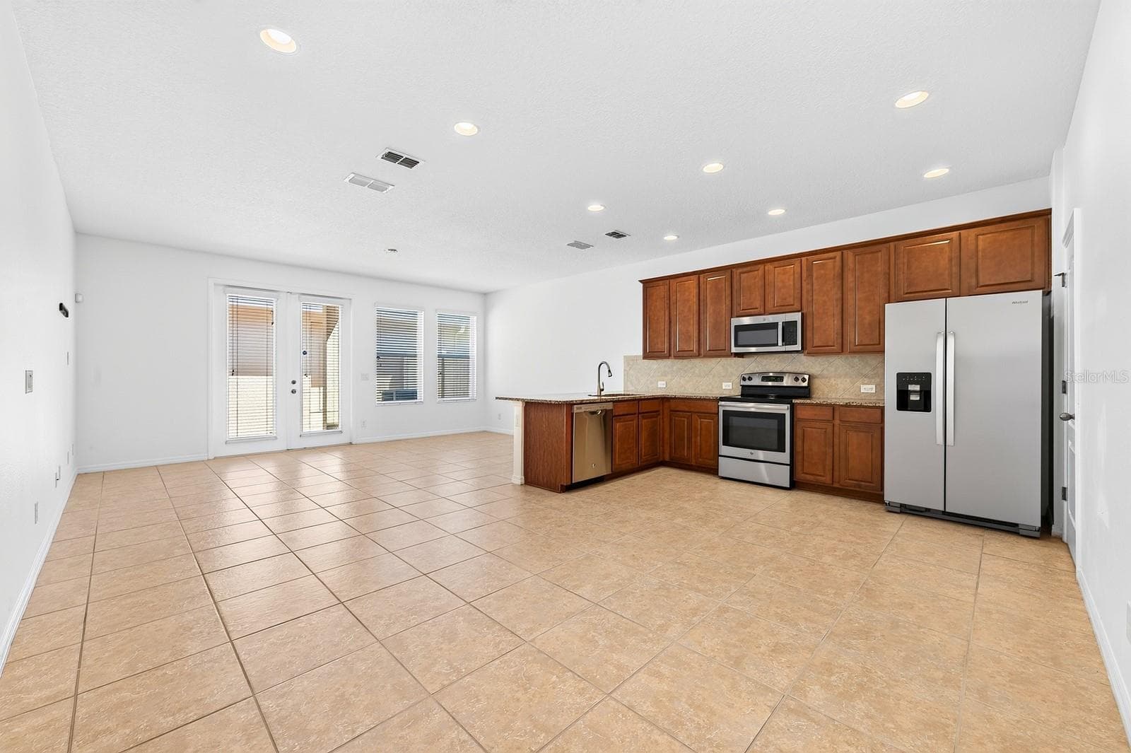 Inside, TILE & WOOD LAMINATE FLOORING flow throughout the home, while the light-filled OPEN CONCEPT design makes everyday living and entertaining effortless. - 11429 BROWNSTONE ST, WINDERMERE