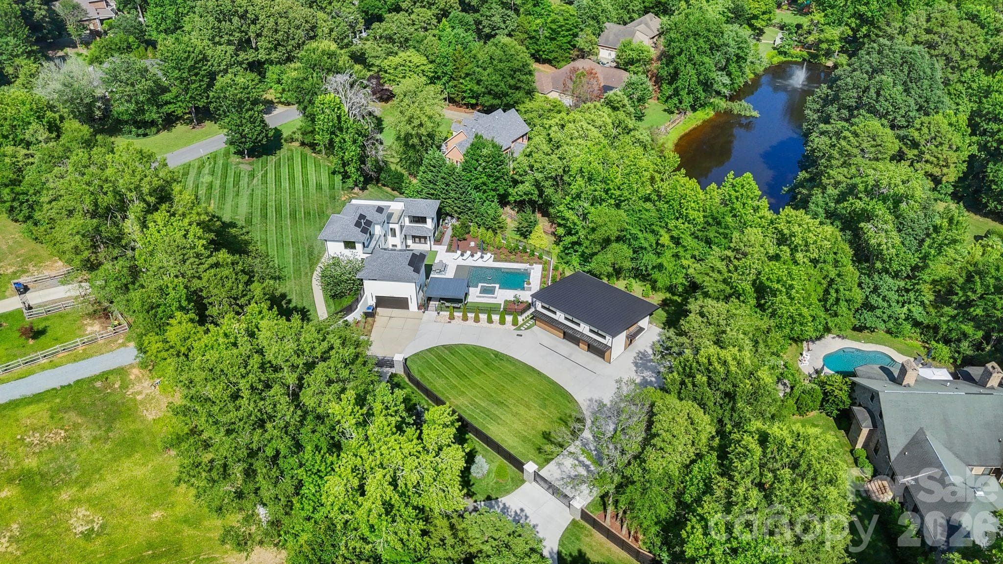 Aerial view of expansive 1.58-acre lot with resort-style backyard and modern architecture - 1064 Greylyn Drive, Matthews