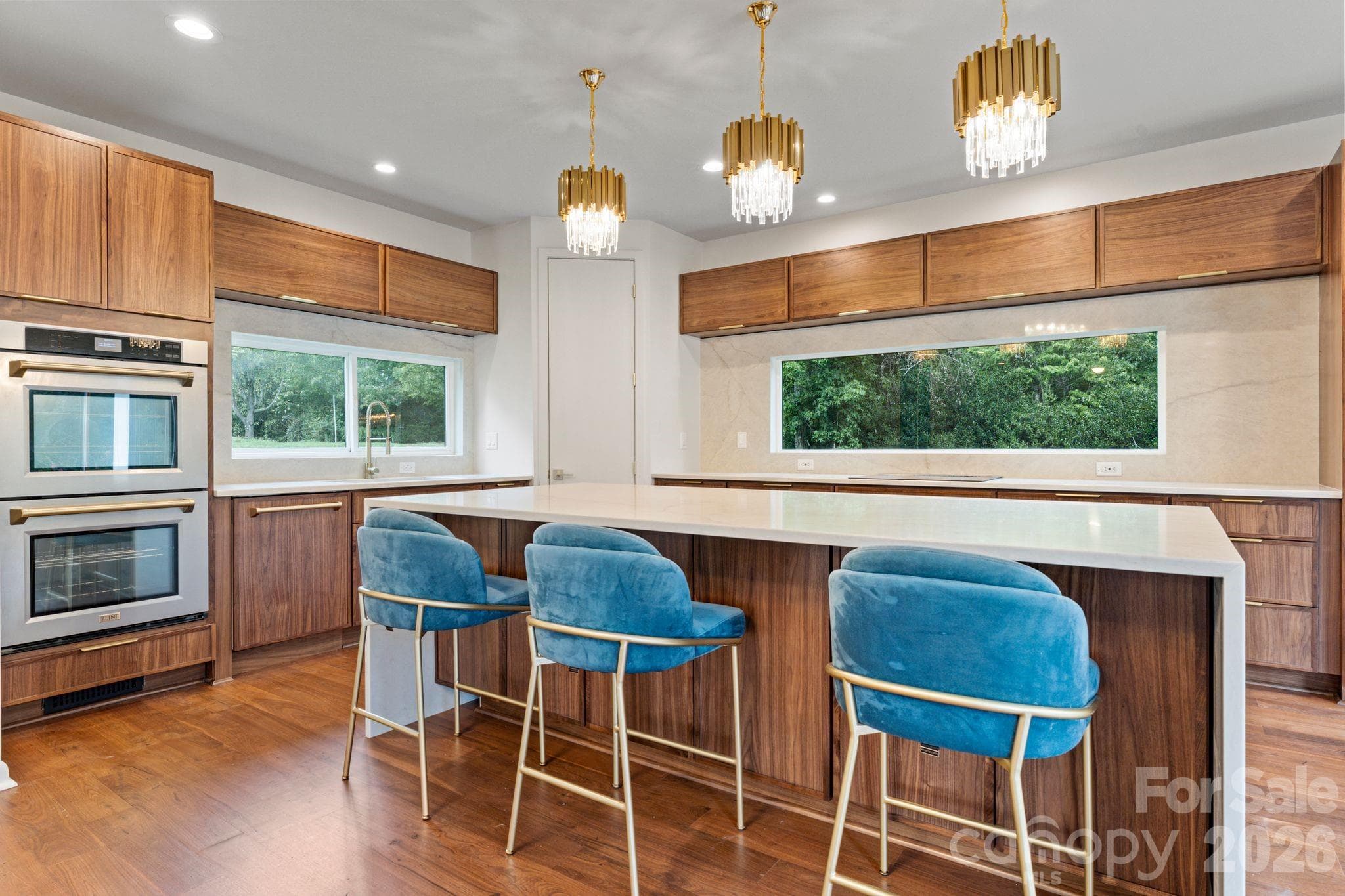 Open-concept gourmet kitchen with breakfast bar seating and designer stainless appliance suite - 1064 Greylyn Drive, Matthews