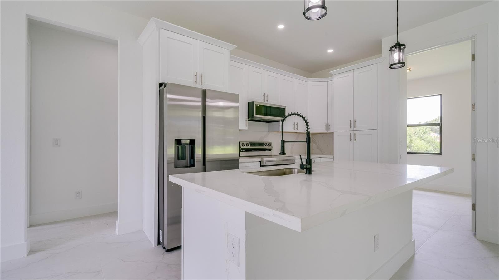Gorgeous cabinetry and quartz countertops & Island. The open door to the right leads to your office/den! - 2713 8TH ST W, LEHIGH ACRES