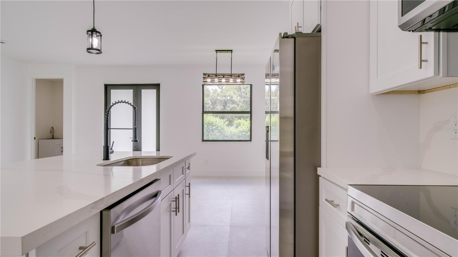 View from kitchen of front door. Laundry room is to the left. Dining area straight ahead. - 2713 8TH ST W, LEHIGH ACRES
