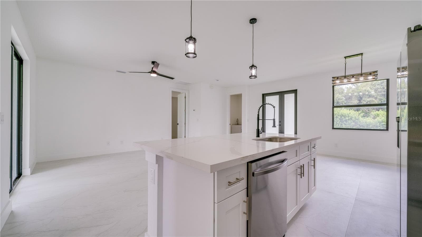 Another view from the kitchen showing the great room. Door on far wall leads to the Primary En-suite! - 2713 8TH ST W, LEHIGH ACRES