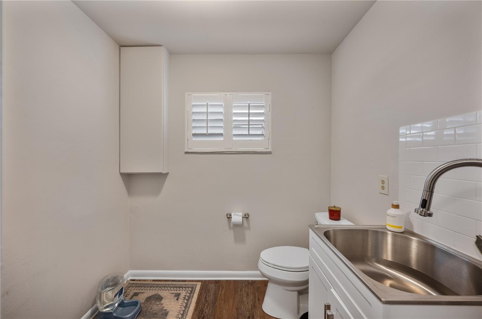 Large half bathroom right off the kitchen features ample space to dog condos as well! - 1211 HUNT AVE, LAKELAND