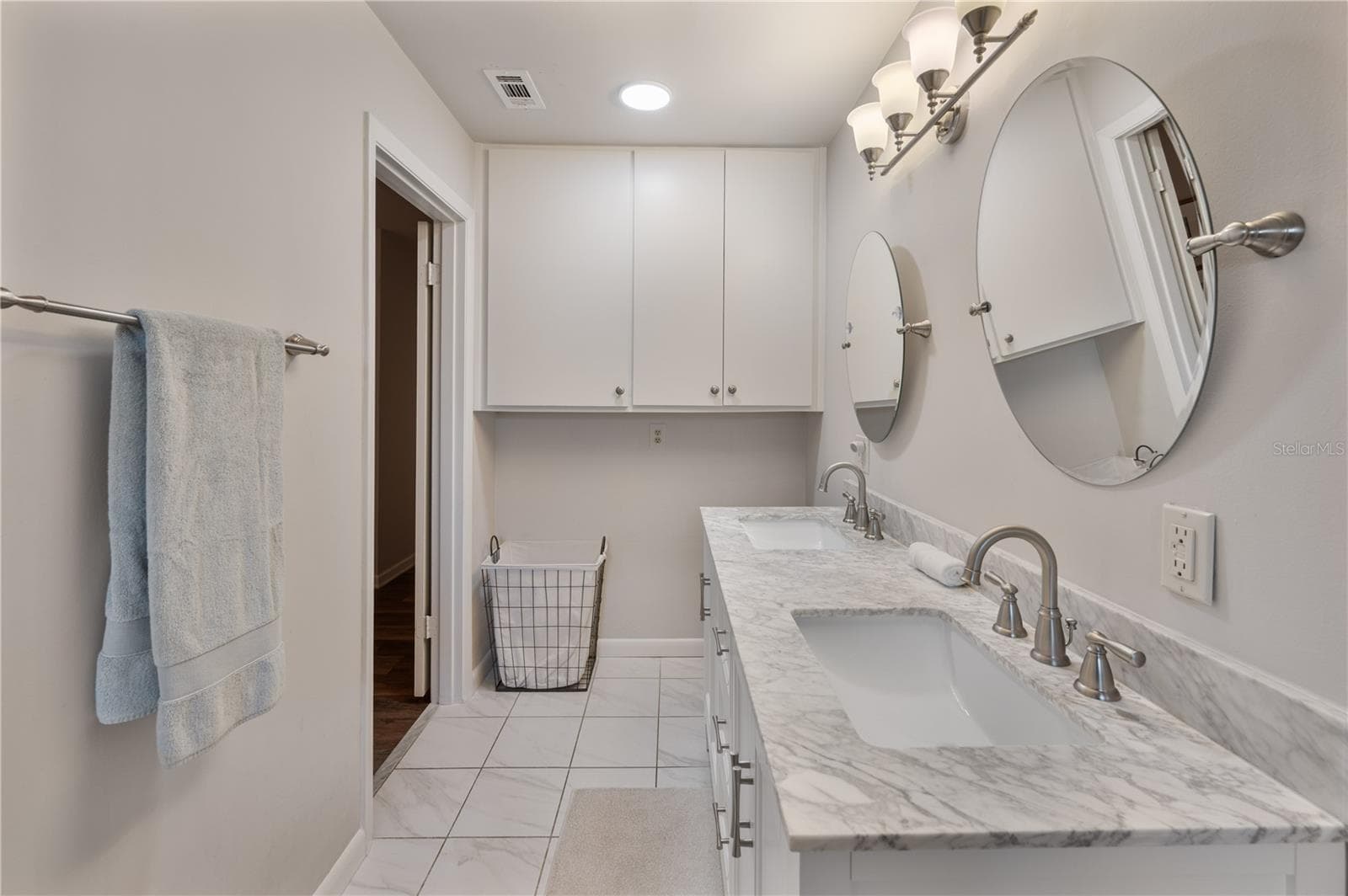 The primary Bathroom has additional storage and a perfect place for the clothing hamper - 1211 HUNT AVE, LAKELAND