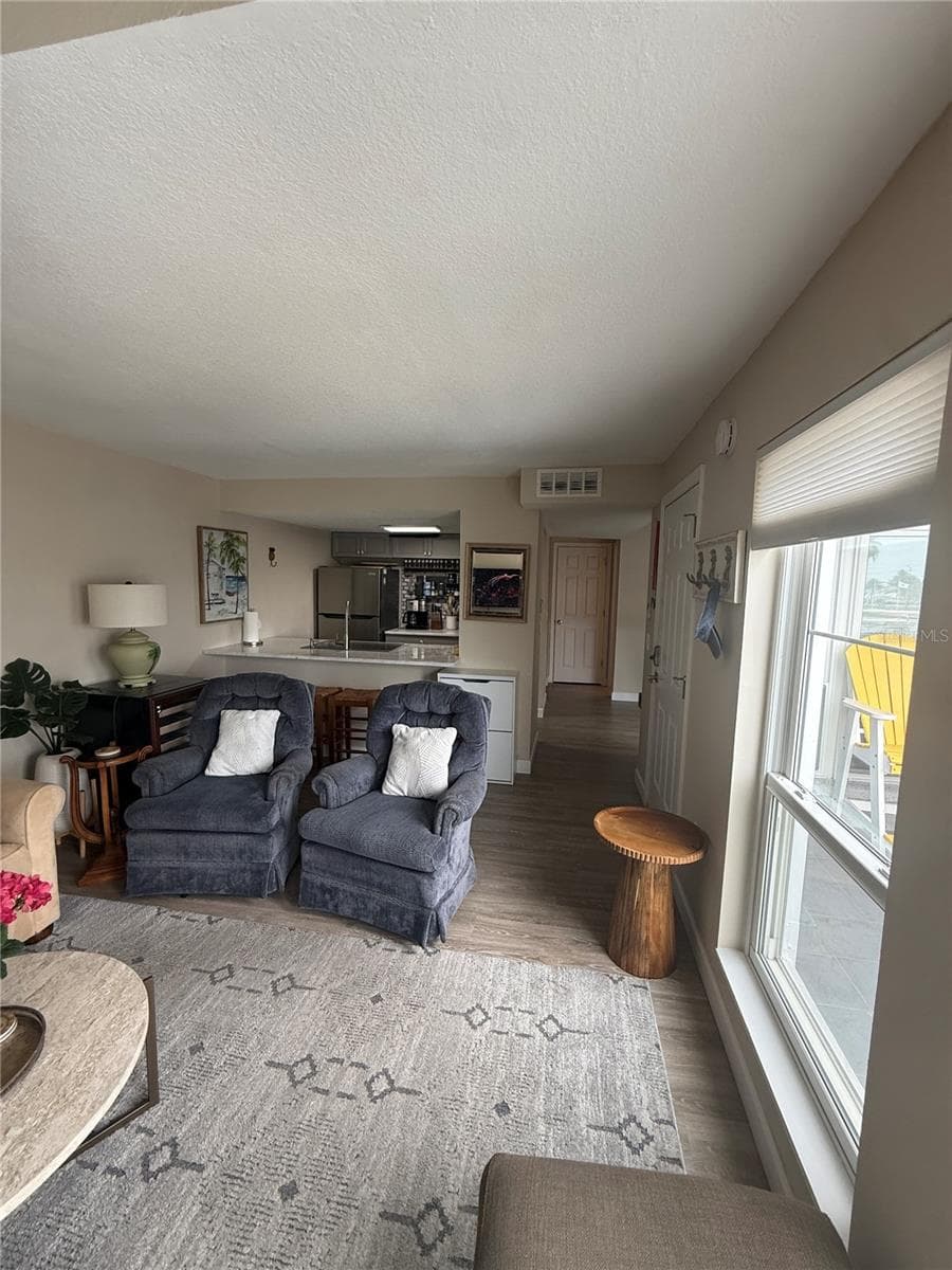 Living room leads to kitchen and dining room - 315 MEDALLION BLVD #H, MADEIRA BEACH