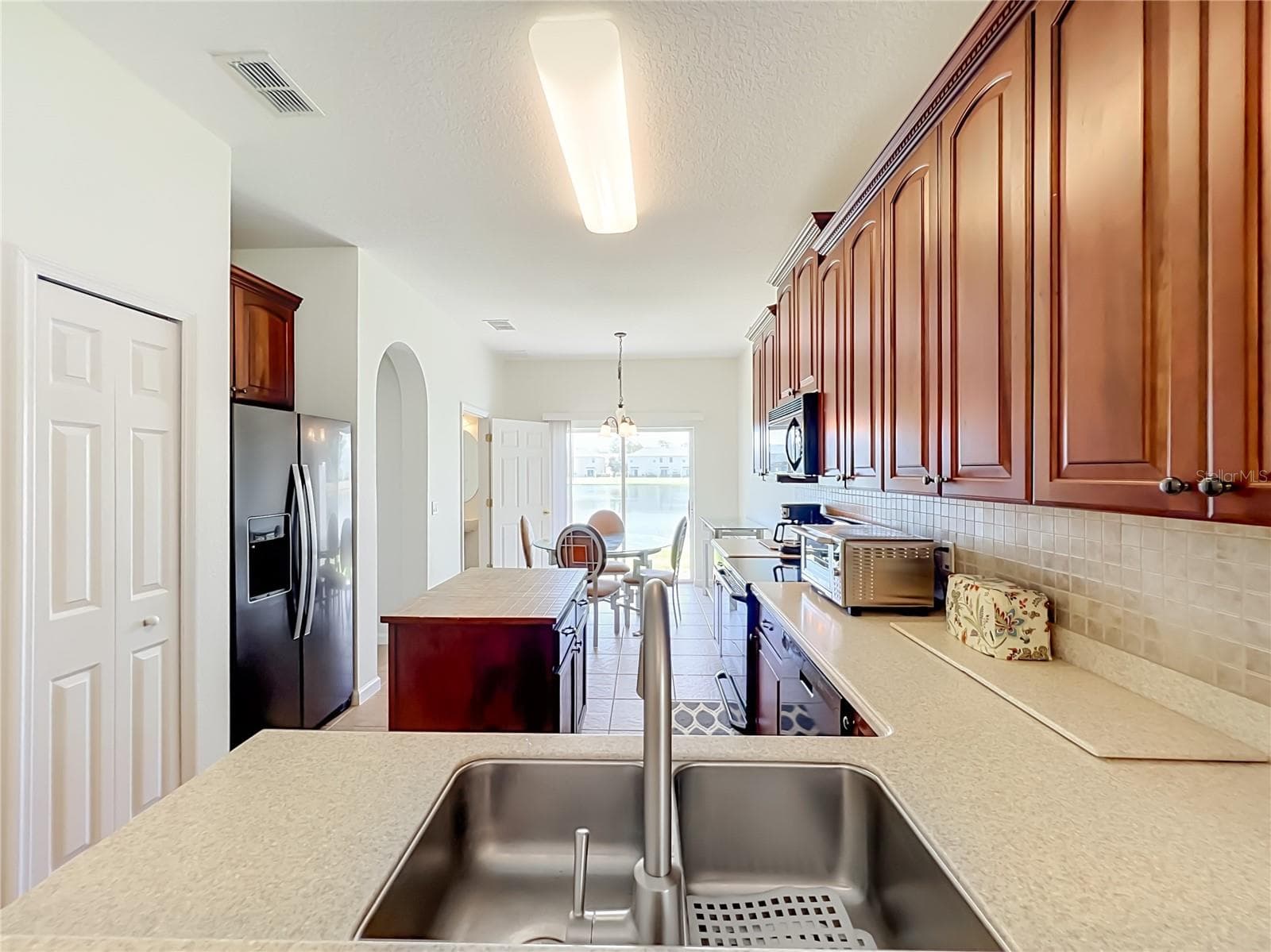 Spacious kitchen with traditional large cabinets, Corian countertops and well-kept appliances. - 16543 CEDAR CREST DR, ORLANDO