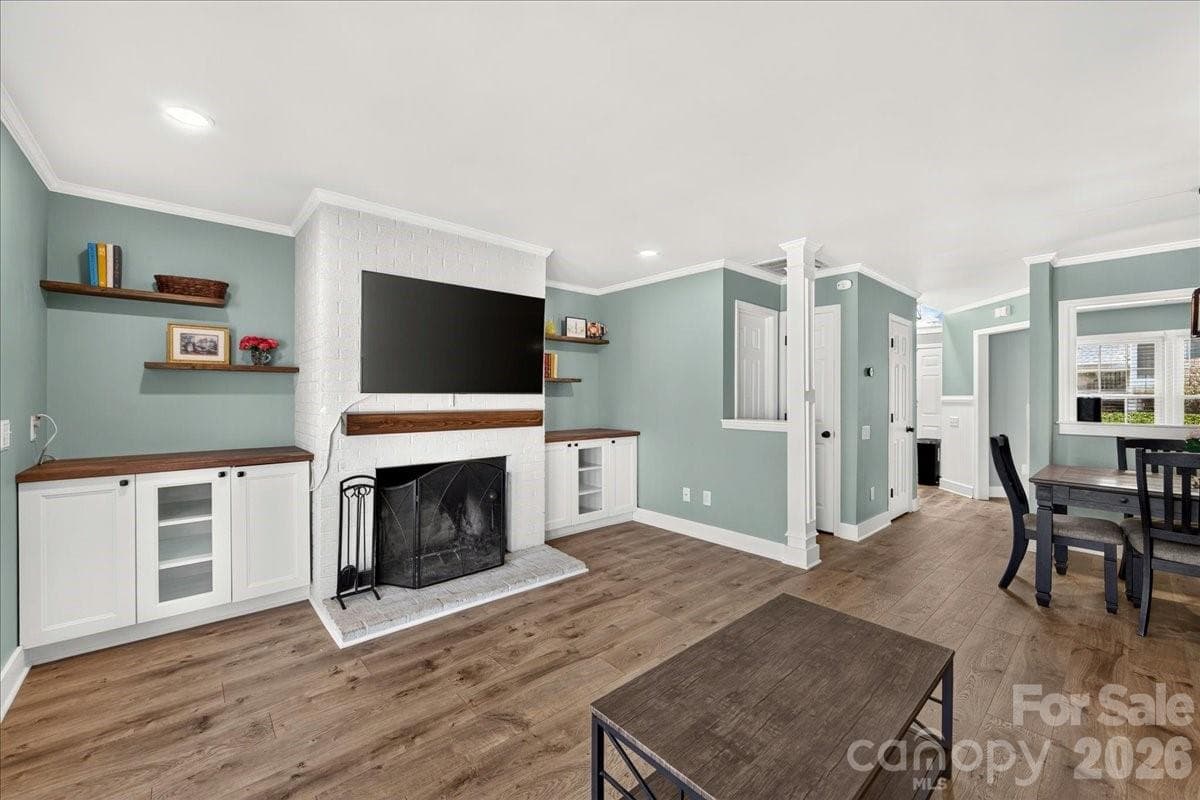 Living room with fireplace and white painted brick surround - 8220 Legare Court, Charlotte