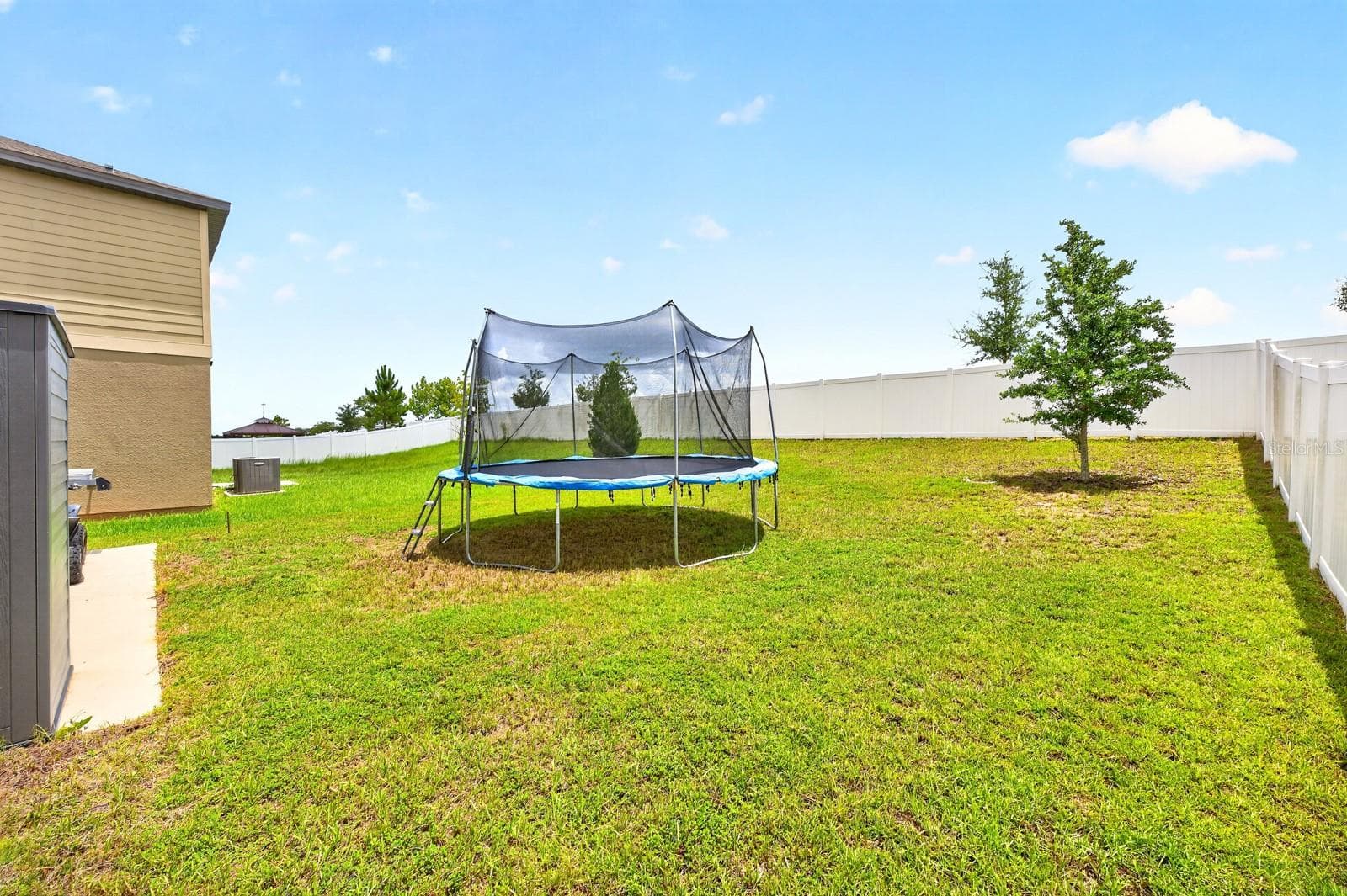 Step out to the backyard, where you'll find a patio overlooking the expansive, partially fenced yard complete with a STORAGE SHED. - 1961 HEMINGWAY CIR, GROVELAND
