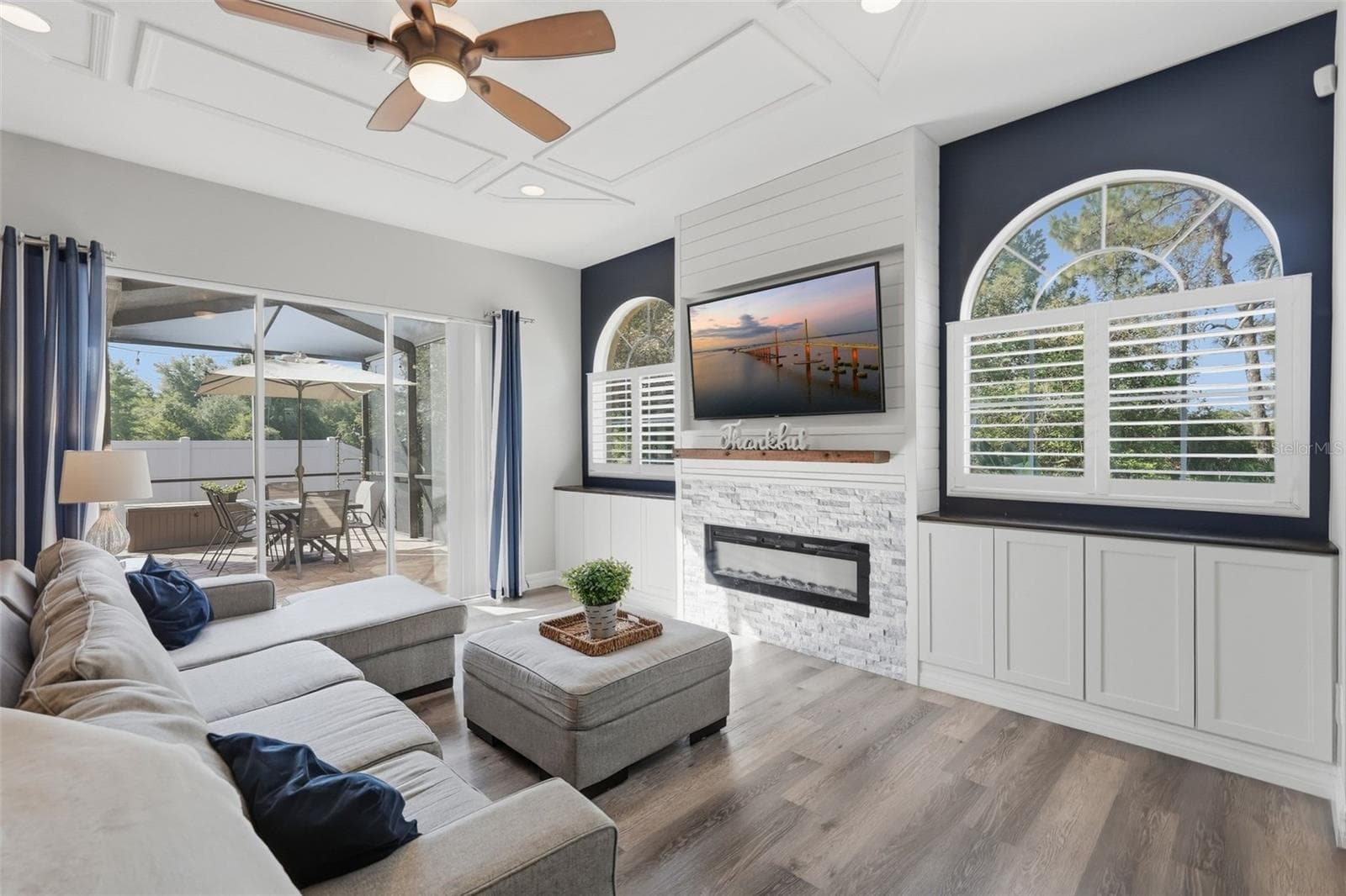 Electric Fireplace warms the room. built in cabinetry with plantation shutters - 12903 DRAKEFIELD DR, SPRING HILL