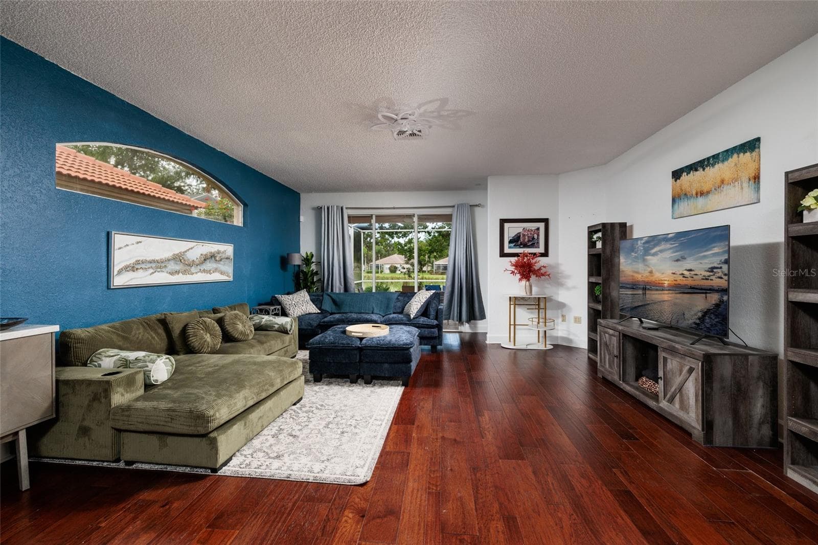 Living room with sliders to a large lanai with pond view. - 1338 DARTFORD DR, TARPON SPRINGS
