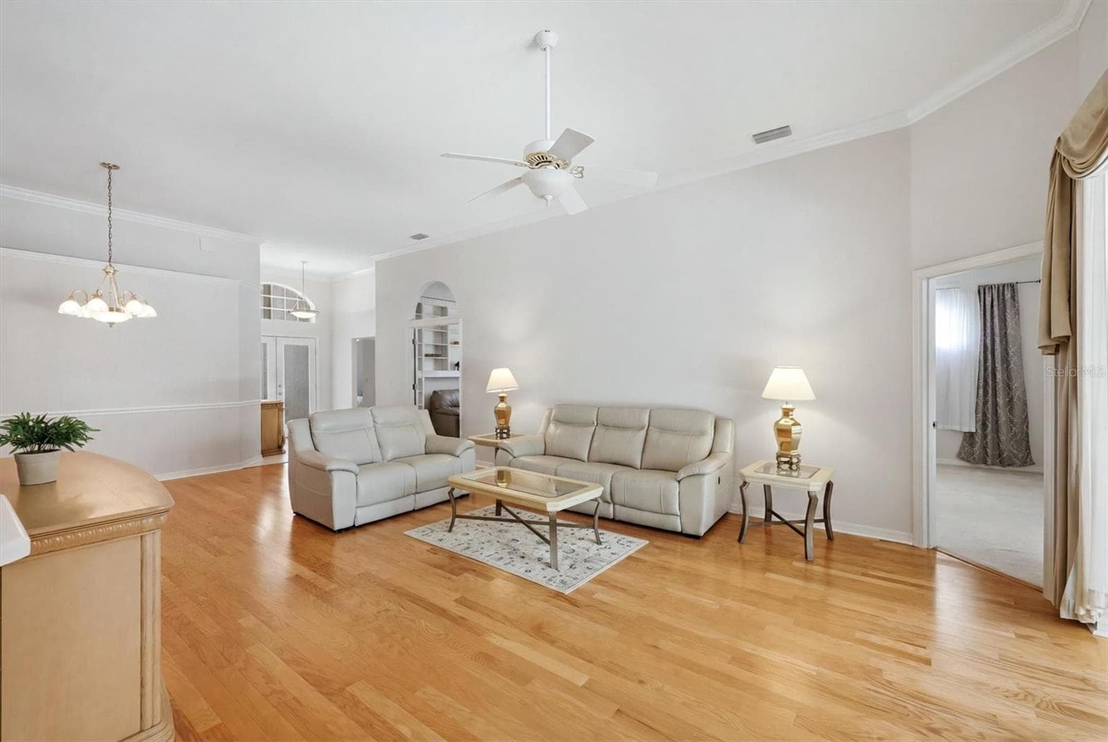 Open-concept living and dining area with hardwood flooring in Lakewood Ranch home - 8492 IDLEWOOD CT, LAKEWOOD RANCH