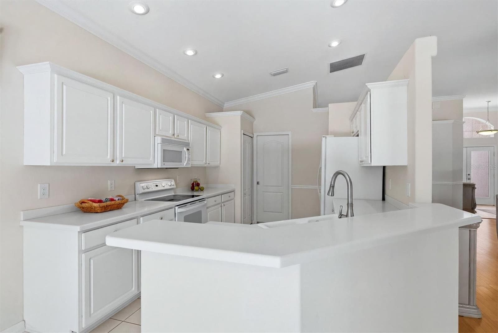 Bright white kitchen with island, modern cabinetry and abundant natural light - 8492 IDLEWOOD CT, LAKEWOOD RANCH