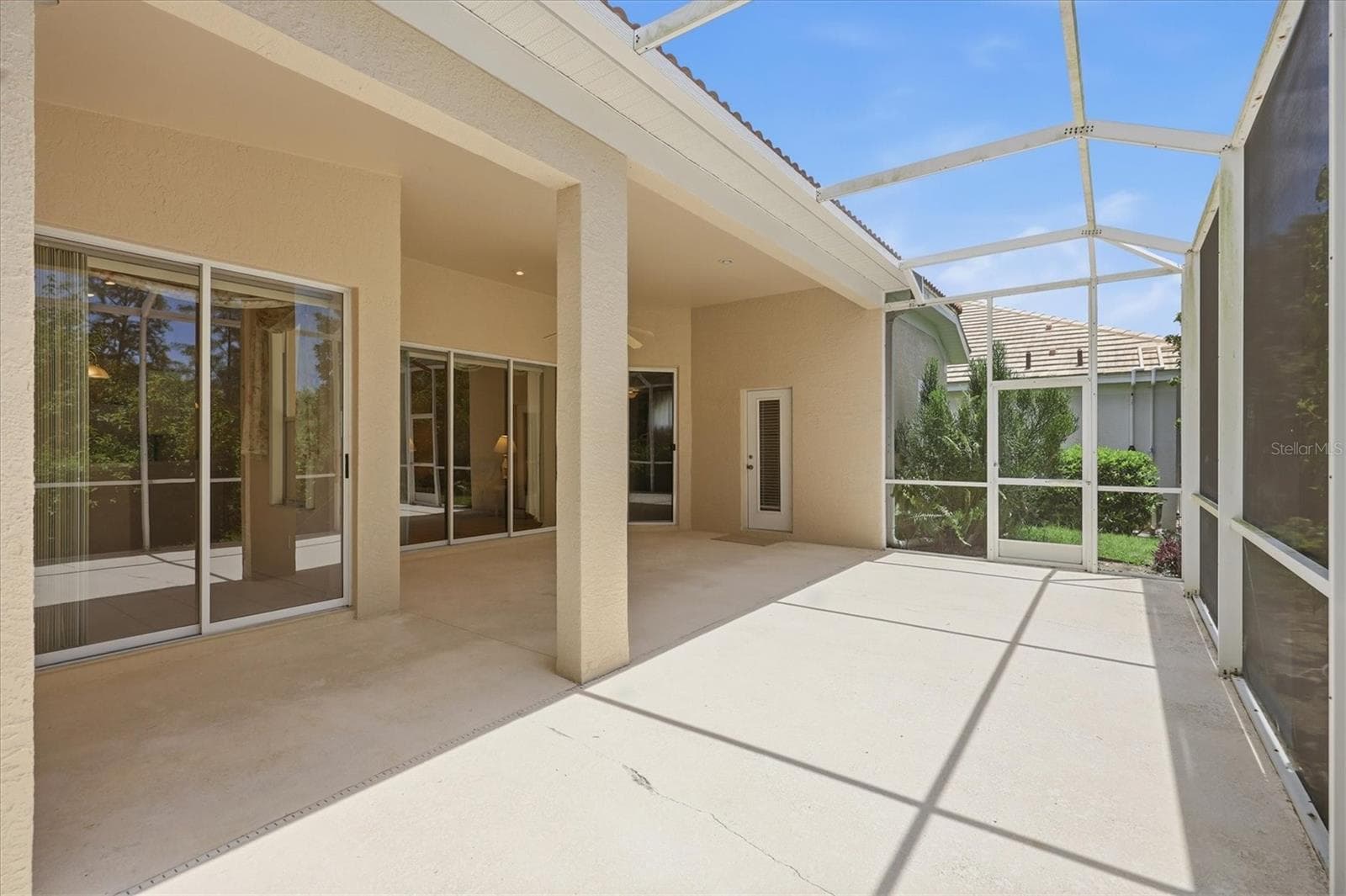 Spacious screened lanai with covered outdoor living area and views of landscaped surroundings - 8492 IDLEWOOD CT, LAKEWOOD RANCH