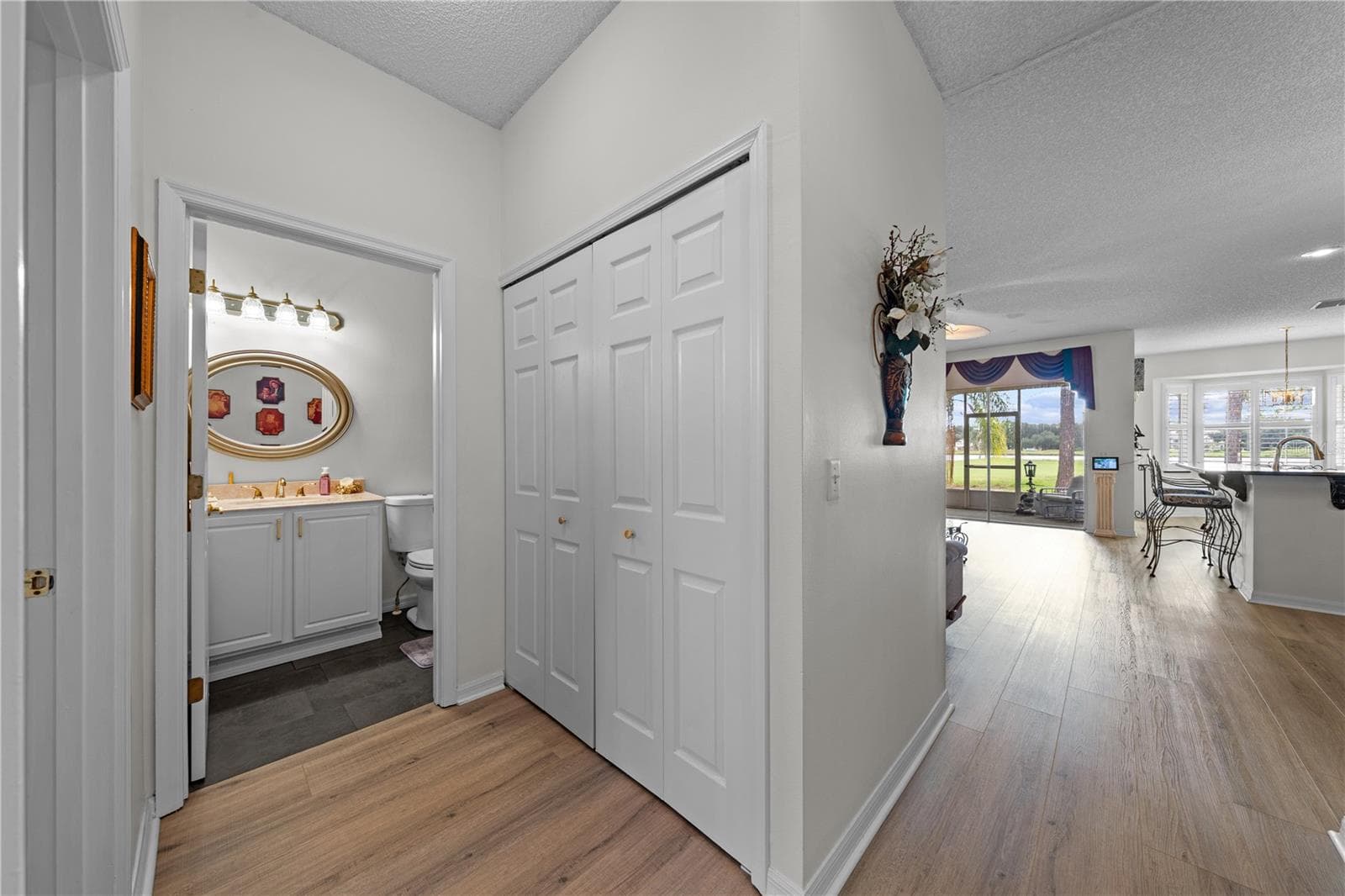 View from the foyer - guest bathroom to the left and living area and kitchen to the right. - 153 CLUB VILLAS LN, KISSIMMEE
