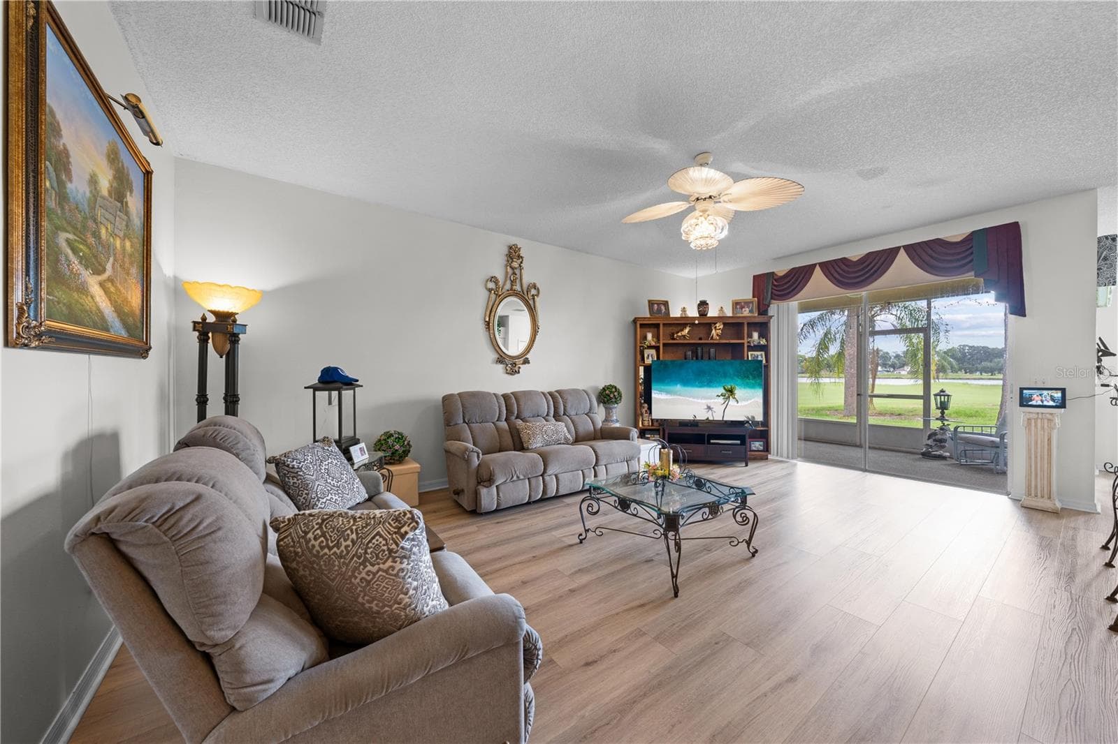 Living Room with view of the screened lanai and golf course. - 153 CLUB VILLAS LN, KISSIMMEE