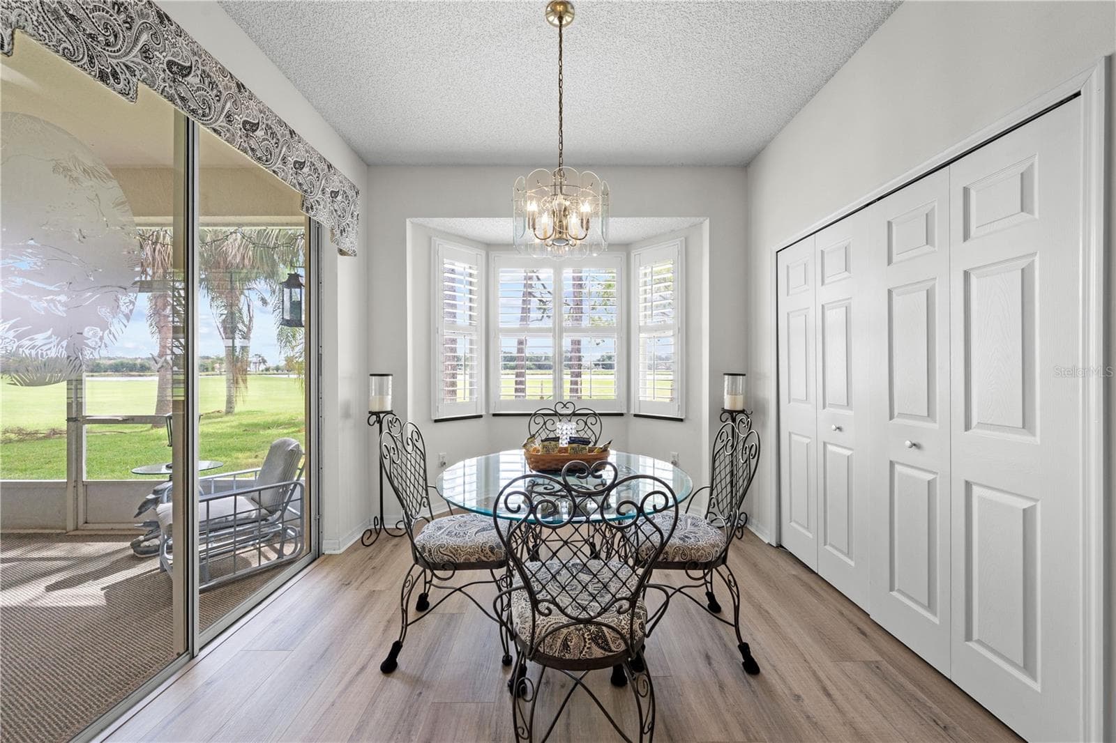 Dinette with the view of the lanai and golf course.  Plantation shutters for sunny days - 153 CLUB VILLAS LN, KISSIMMEE