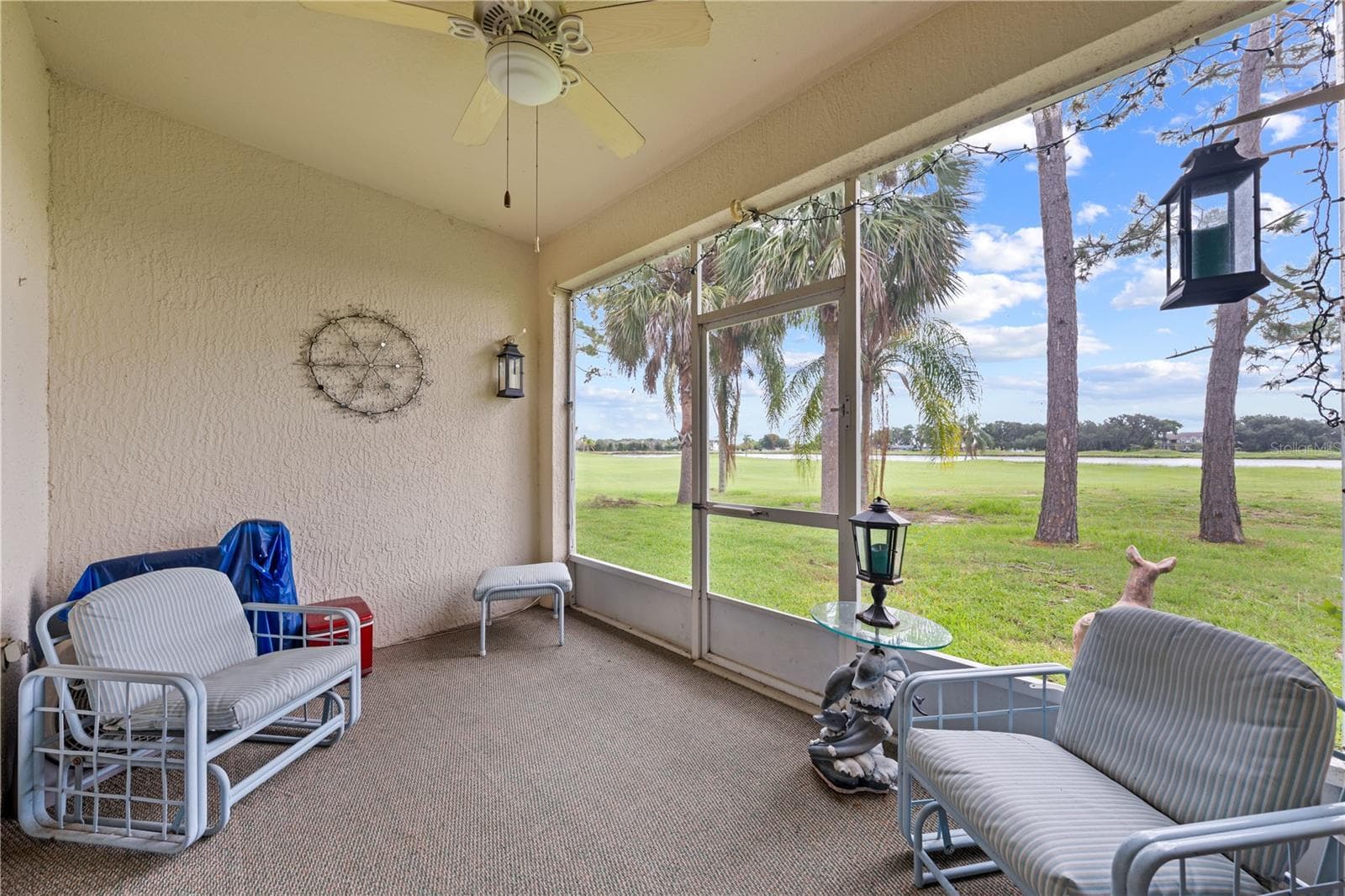 Screened and covered lanai with a few of the golf course. - 153 CLUB VILLAS LN, KISSIMMEE