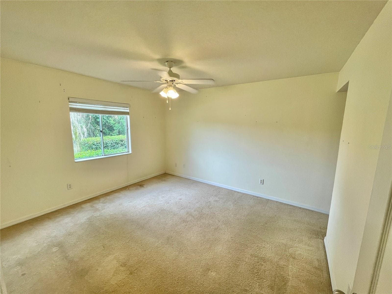 unstaged primary bedroom with lake view, en-suite bathroom, walk in closet and ceiling fan - 145 N PEARL LAKE CSWY #112, ALTAMONTE SPRINGS
