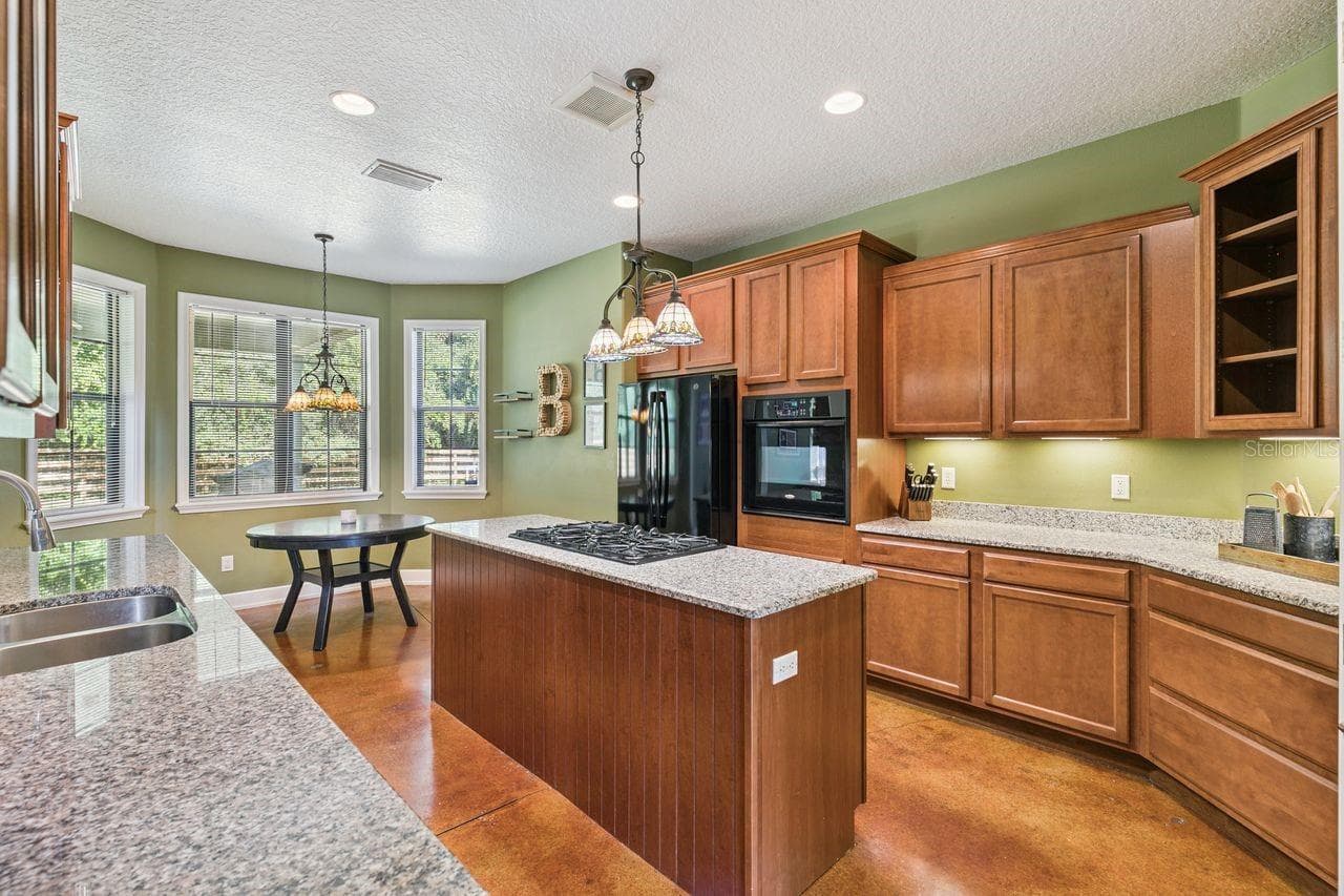 Kitchen with Granite Countertops, Cooking Island, Pantry, New Refrigerator - 36137 MATTAWAN DR, EUSTIS