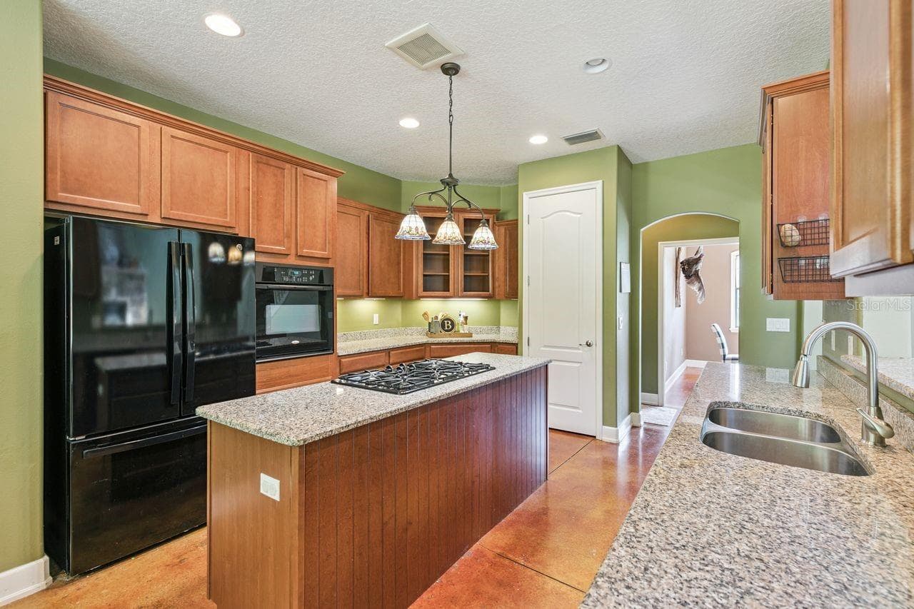Kitchen with Granite Countertops, Cooking Island, Pantry, New Refrigerator - 36137 MATTAWAN DR, EUSTIS