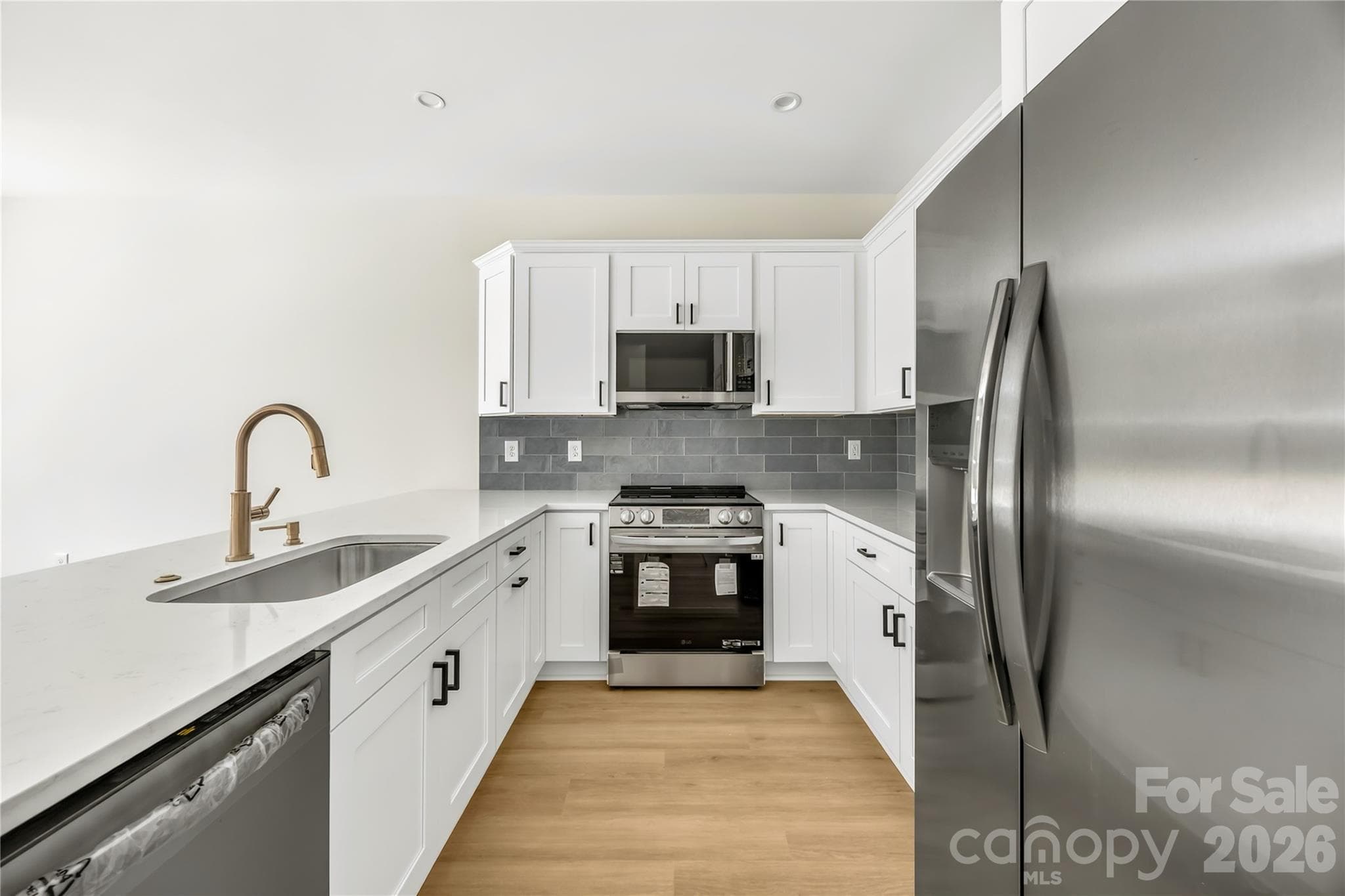 Kitchen with quartz countertops, tile backsplash and stainless steel appliances, refrigerator included, at 1940 Purser Dr in Charlotte - 1940 Purser Drive, Charlotte