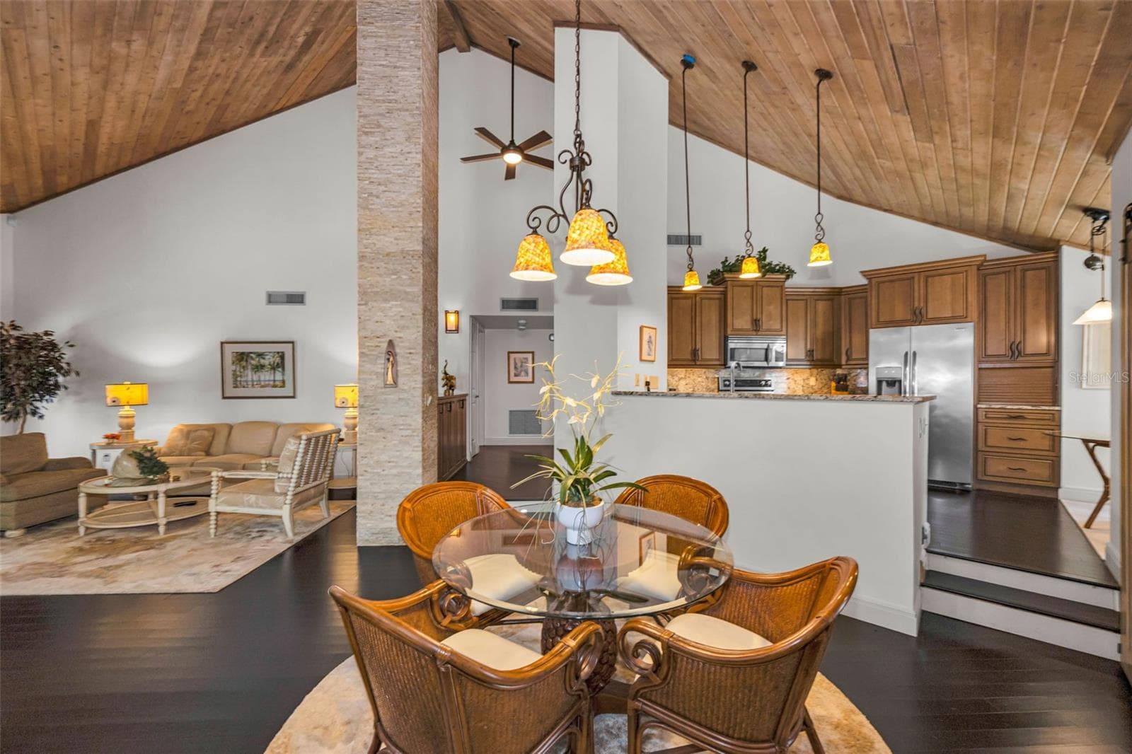 Living room, formal dining and the beautiful kitchen! Note the tongue and groove vaulted ceiling and the stacked stone details! It's a lovely home! - 10497 LONGWOOD DR, SEMINOLE