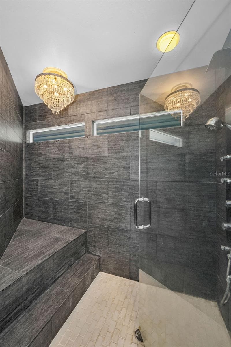 Master shower with bench and chandelier - 10497 LONGWOOD DR, SEMINOLE
