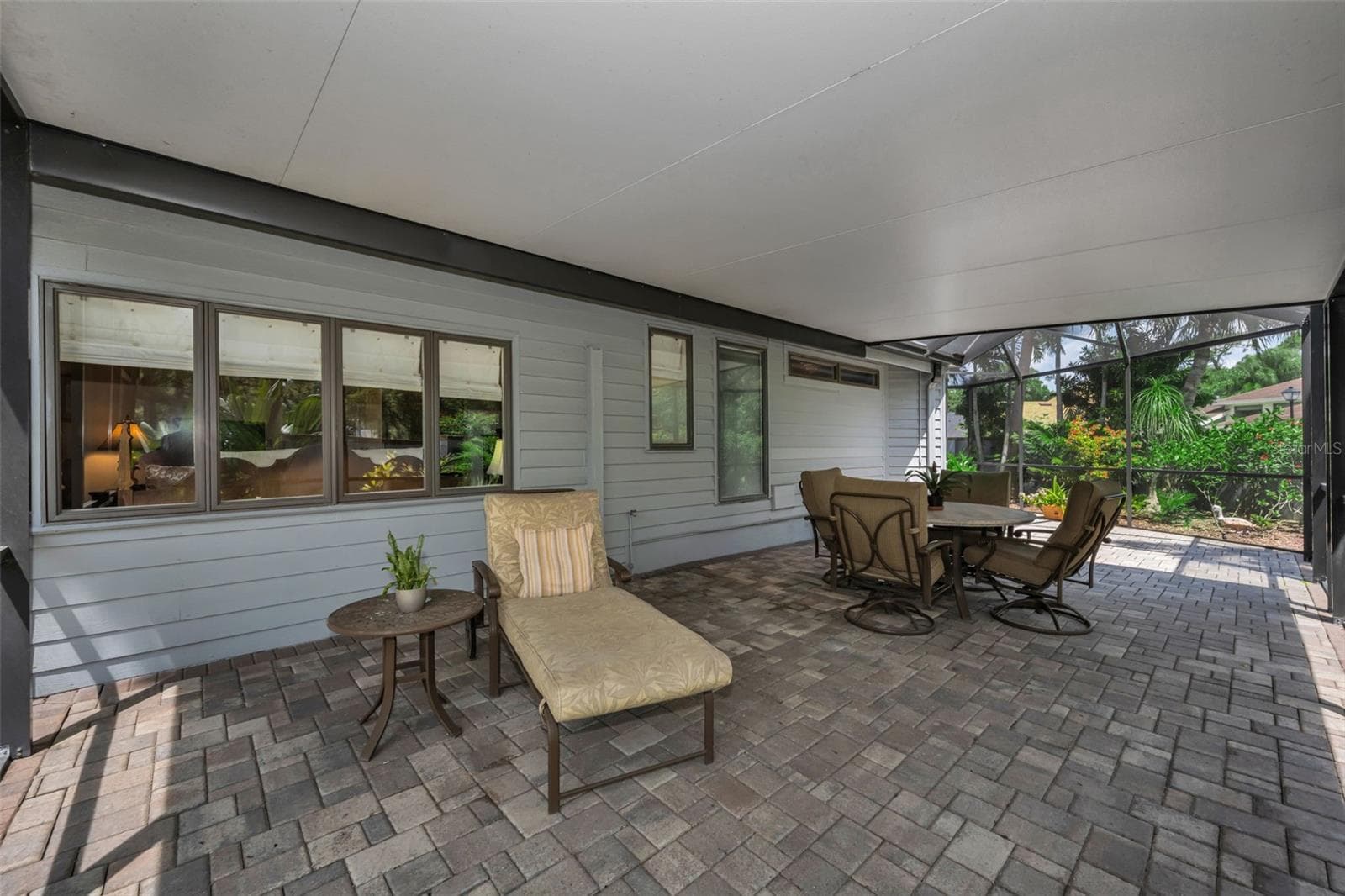 Screened and covered section of the pond side patio. So perfect for reading and chatting with neighbors! Not another home like it in the community! - 10497 LONGWOOD DR, SEMINOLE